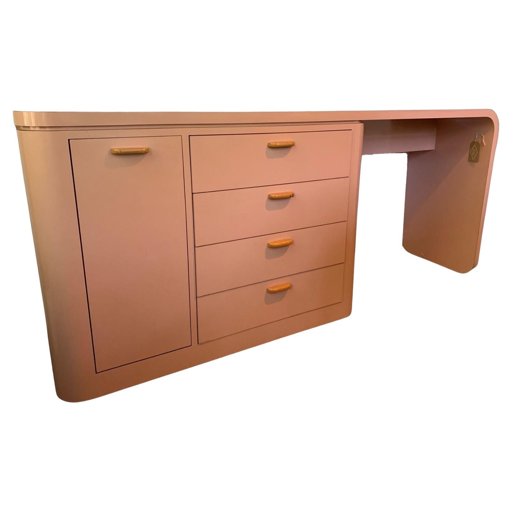 This sleek of vintage desk would be a funky addition to a living room, den, or office. Crafted in the United States circa 1960 and covered in a light pink laminate, the desk is designed for a left-handed user, with the drawers situated on the left
