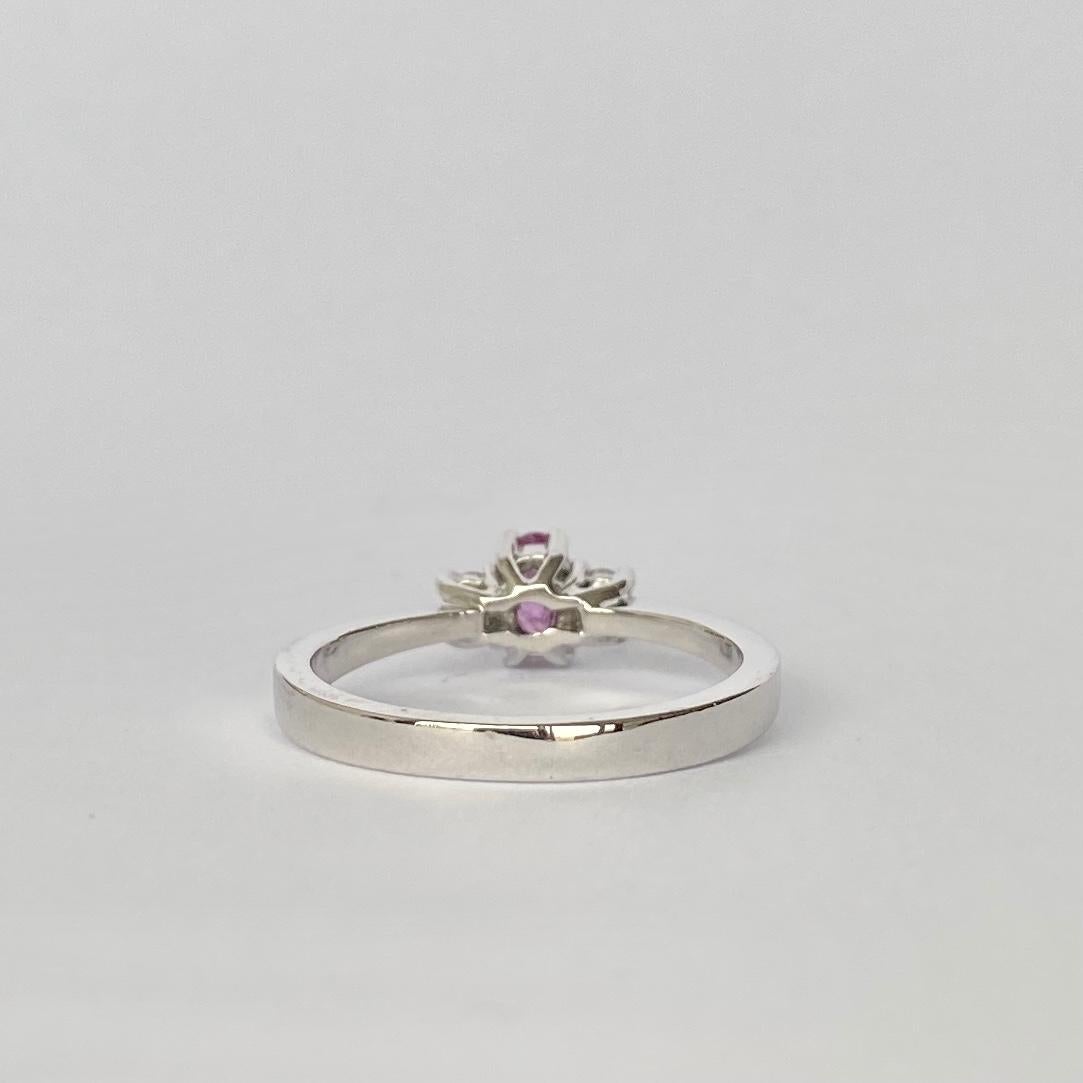 This three stone ring holds a gorgeous pink sapphire at the centre and two round sparkly diamonds either side. The sapphire measures 30pts and the diamonds total 10pts. The ring is modelled in platinum.

Ring Size: M or 6 1/4 
Height Off Finger: