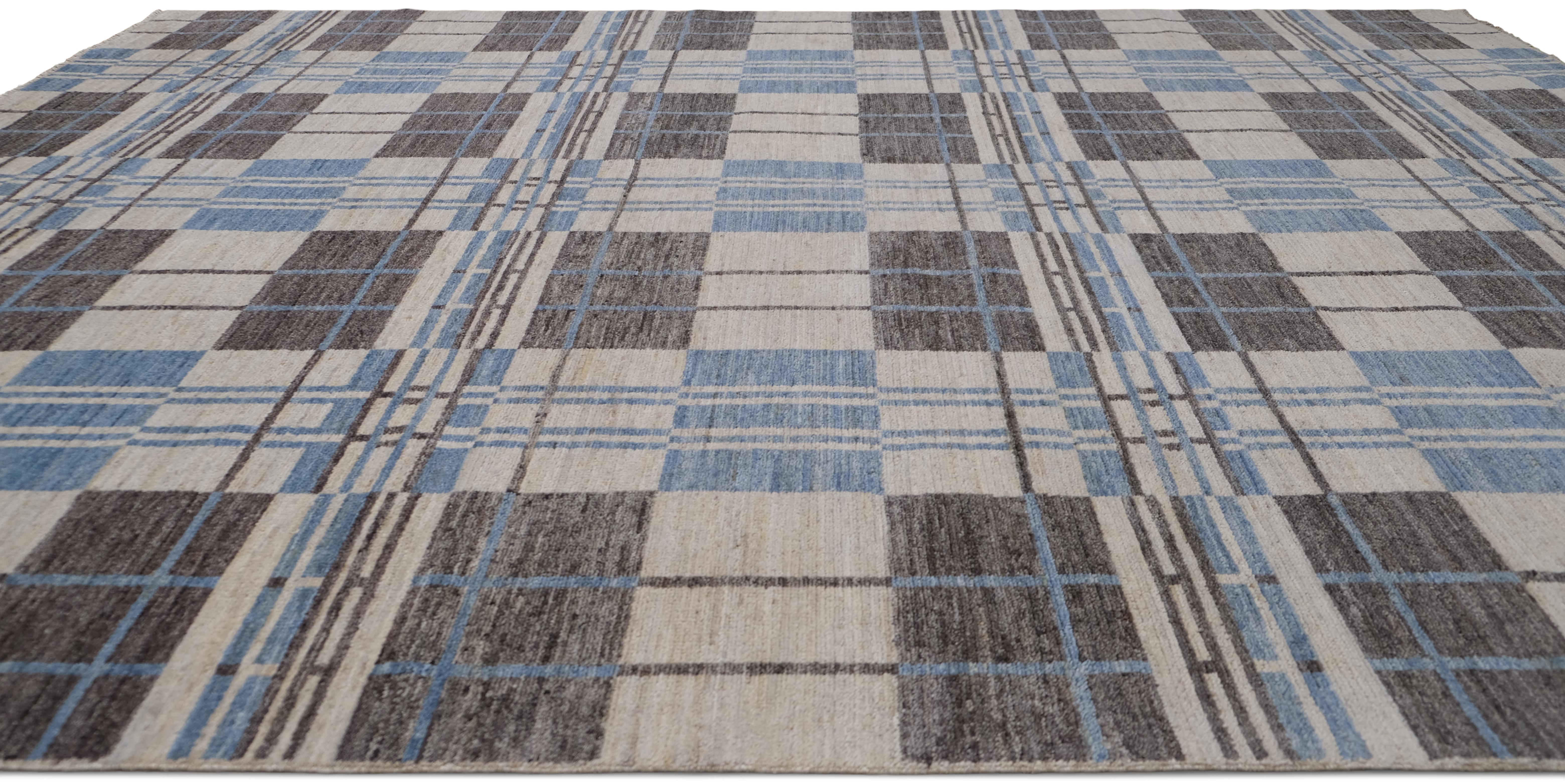 Introduce un encanto atemporal en tu interior con esta alfombra de lana anudada a mano, que presenta un diseño a cuadros contemporáneo en una sofisticada paleta de beige, azul suave y gris. El diseño geométrico estructurado añade un toque moderno a