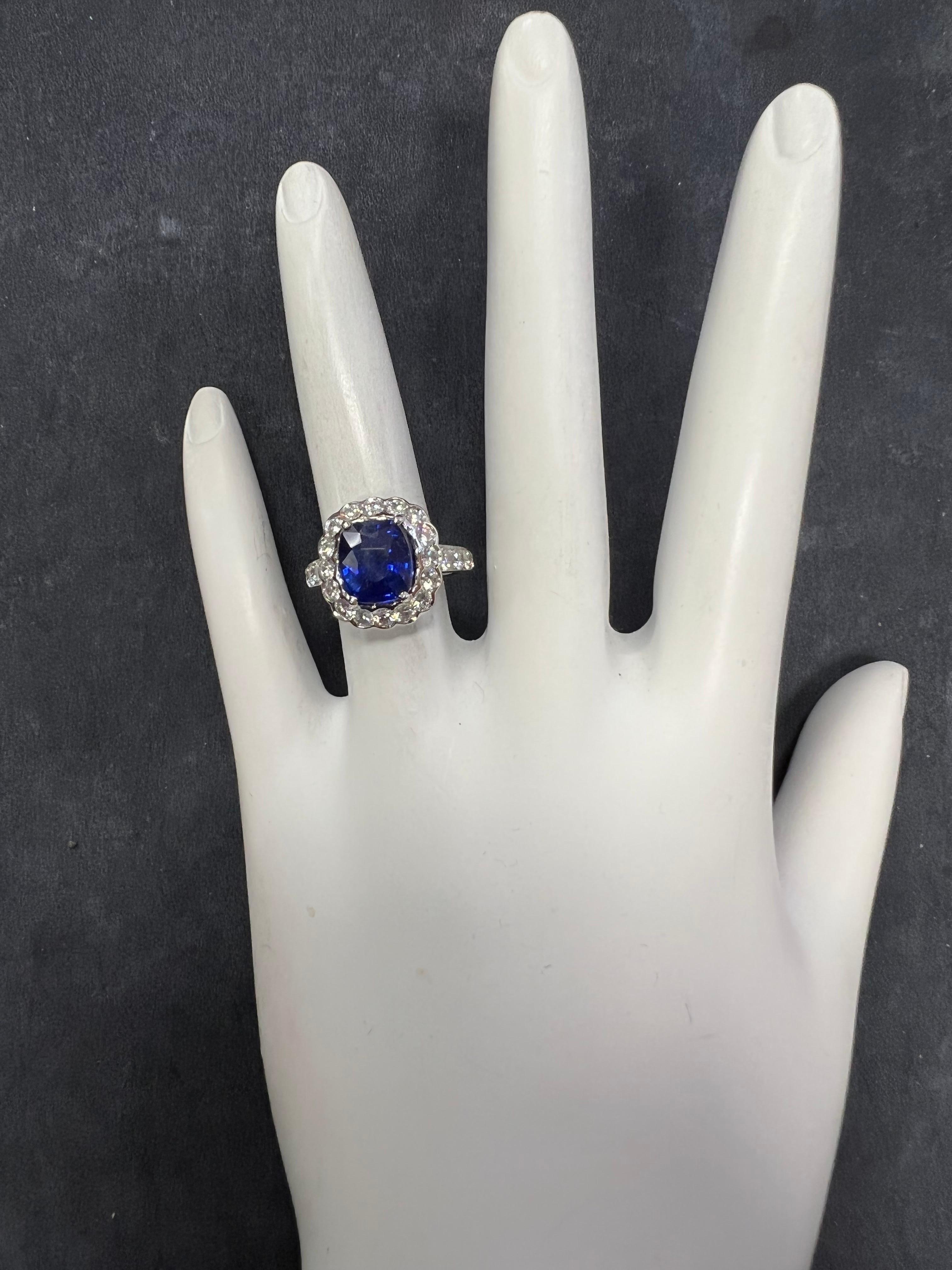 Stunning Modern Platinum Ring.

The 3.15 carat centerstone is a Royal Blue Cushion Shaped heated Sri Lankan Sapphire measuring 8.64x7.53x5.24mm.

The ring is set with 26 natural round brilliant D-E color, VS clarity diamonds weighing 1.14