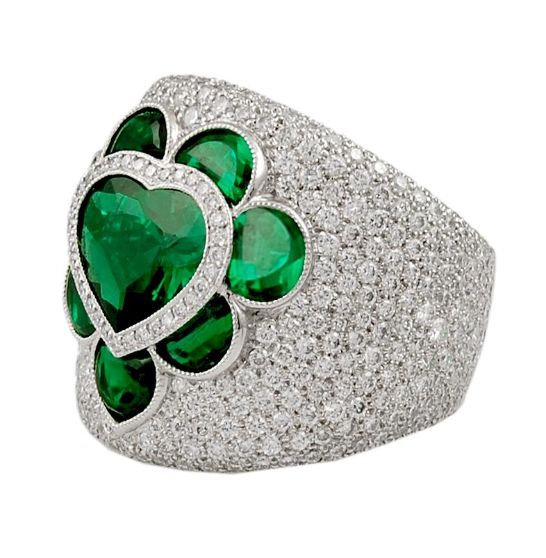 Contemporary Emerald Heart Diamond Bombe Ring in Platinum.

A shallow bombé ring featuring a heart-shaped emerald surrounded by 7 crescent-shaped matching emeralds, embedded in white diamond pavé.

Heart-shaped emerald weight approx. 1.92 carats.