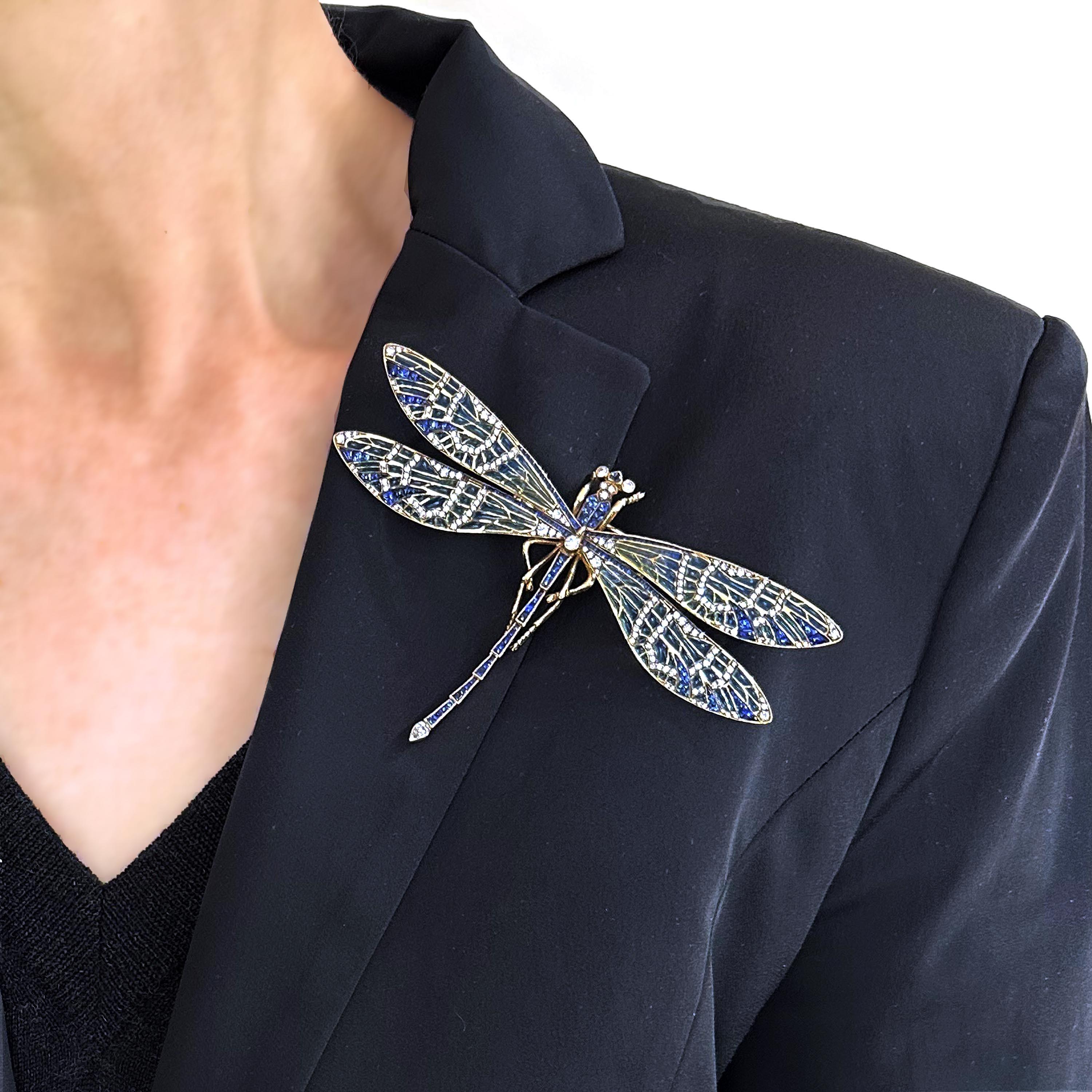 A modern plique à jour enamel gem set dragonfly brooch, with trembling wings, with buff-cut calibré sapphires, with a total weight of 7.40 carats, set in the head, thorax, wings and tail, with blue to green plique à jour enamel wings, with round