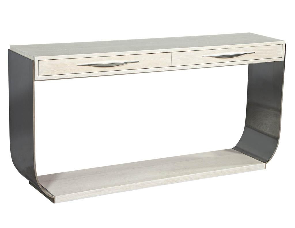 Modern bleached and white washed oak console table with sloping polished stainless sides with two matching drawers with hardware.
Price includes complimentary curb side delivery to the continental USA.