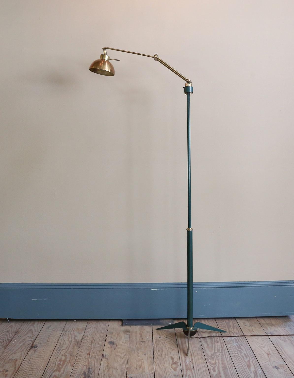 This interesting floor lamp is brass and painted brass. The paint is a green color. The arm moves and the head of the lamp turns as well.