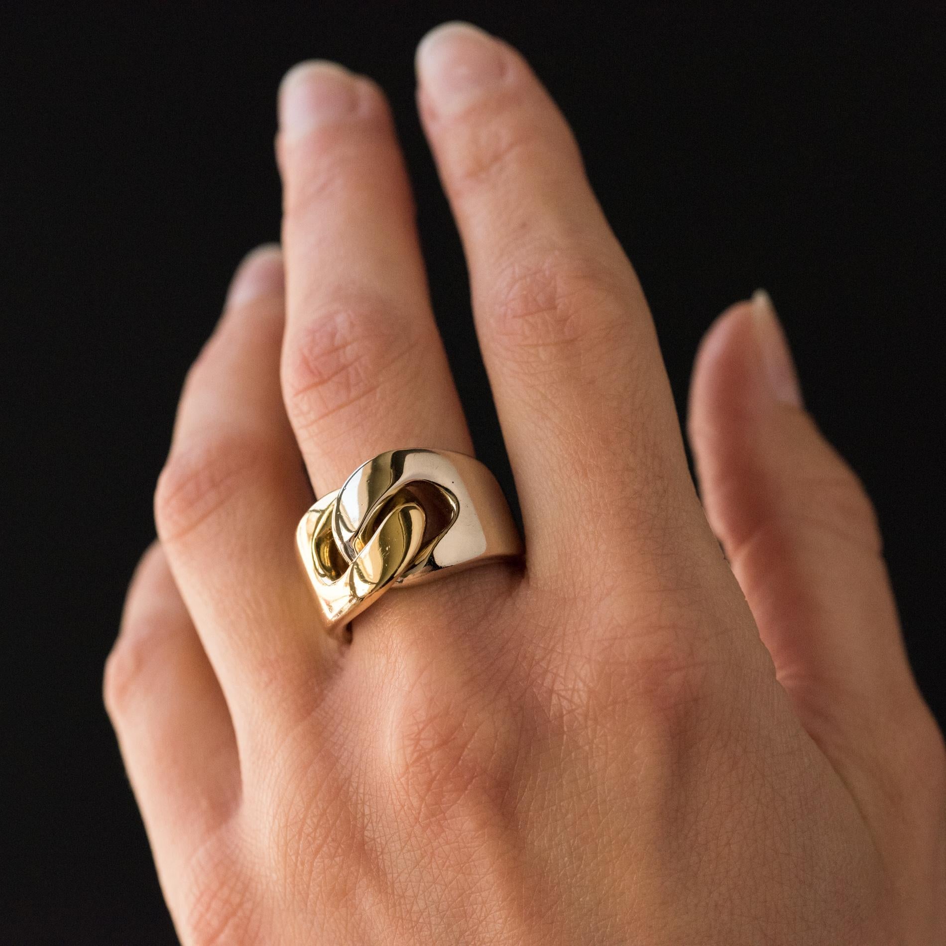 Ring in 18 karats yellow gold and white gold.
Signed Pomellato, this massive ring is composed of 2 rings that meet on the top and intertwine such a curb motif.
Height: 1.4 cm, thickness: 0.5 cm.
Width of the ring at the base: 0.7 cm.
Total weight of