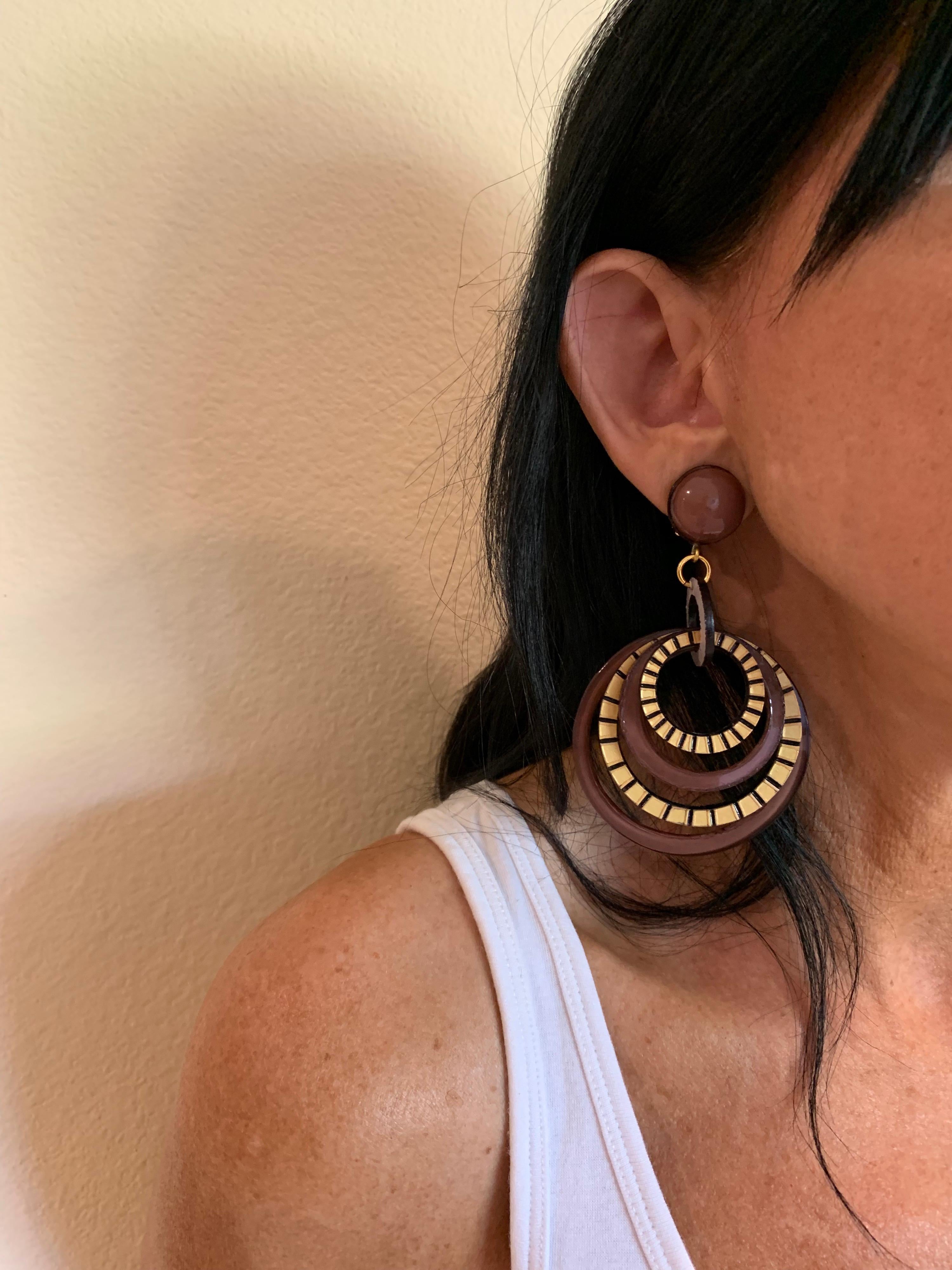 Light and easy to wear, these handmade artisanal hoop clip-on earrings were made in Paris by Cilea. The earrings are comprised of black, brown and gold enameline (resin and enamel composite) and depict three-dimensional pop art circles. Throughout