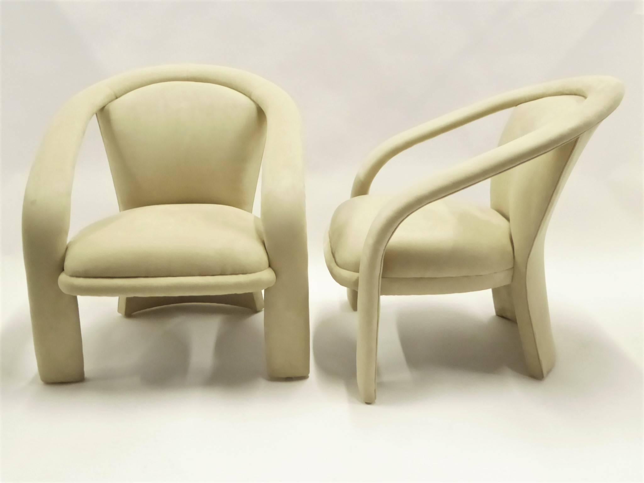 Sporting modern wrap around arms and a fan shaped back, this pair of lounge chairs by Carson's owes inspiration to Milo Baughman. This mid-1980s design newly upholstered in a cream Ultrasuede. Stunning, comfy and late Mid-Century Modern, Space