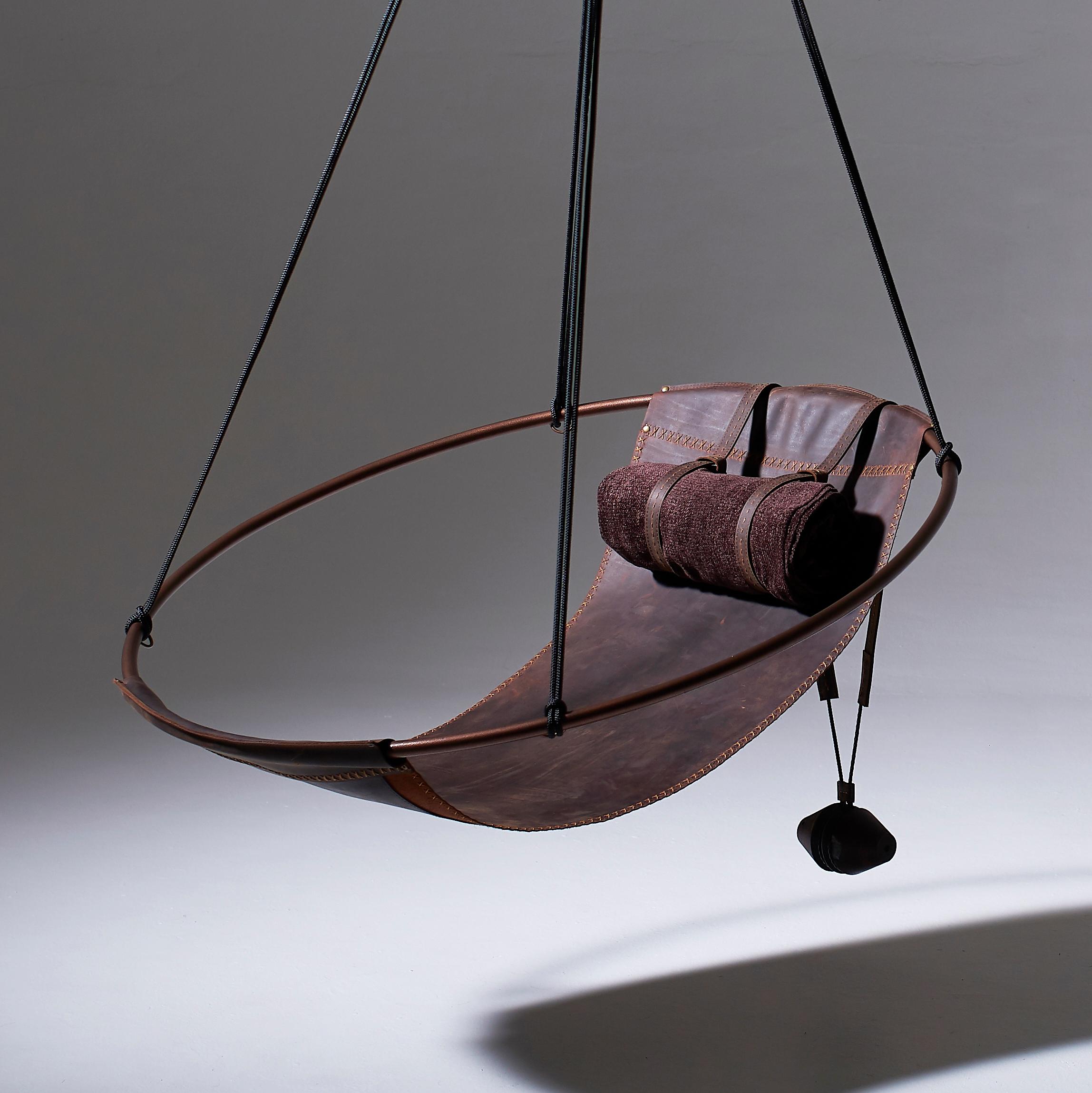 Dépouillé de tout excès, ce fauteuil suspendu présente un cadre circulaire dans lequel les feuilles de cuir ou de tissu pendent librement, pour créer une expérience élégante, sexy et ô combien confortable. Les lignes épurées et la légèreté de cette