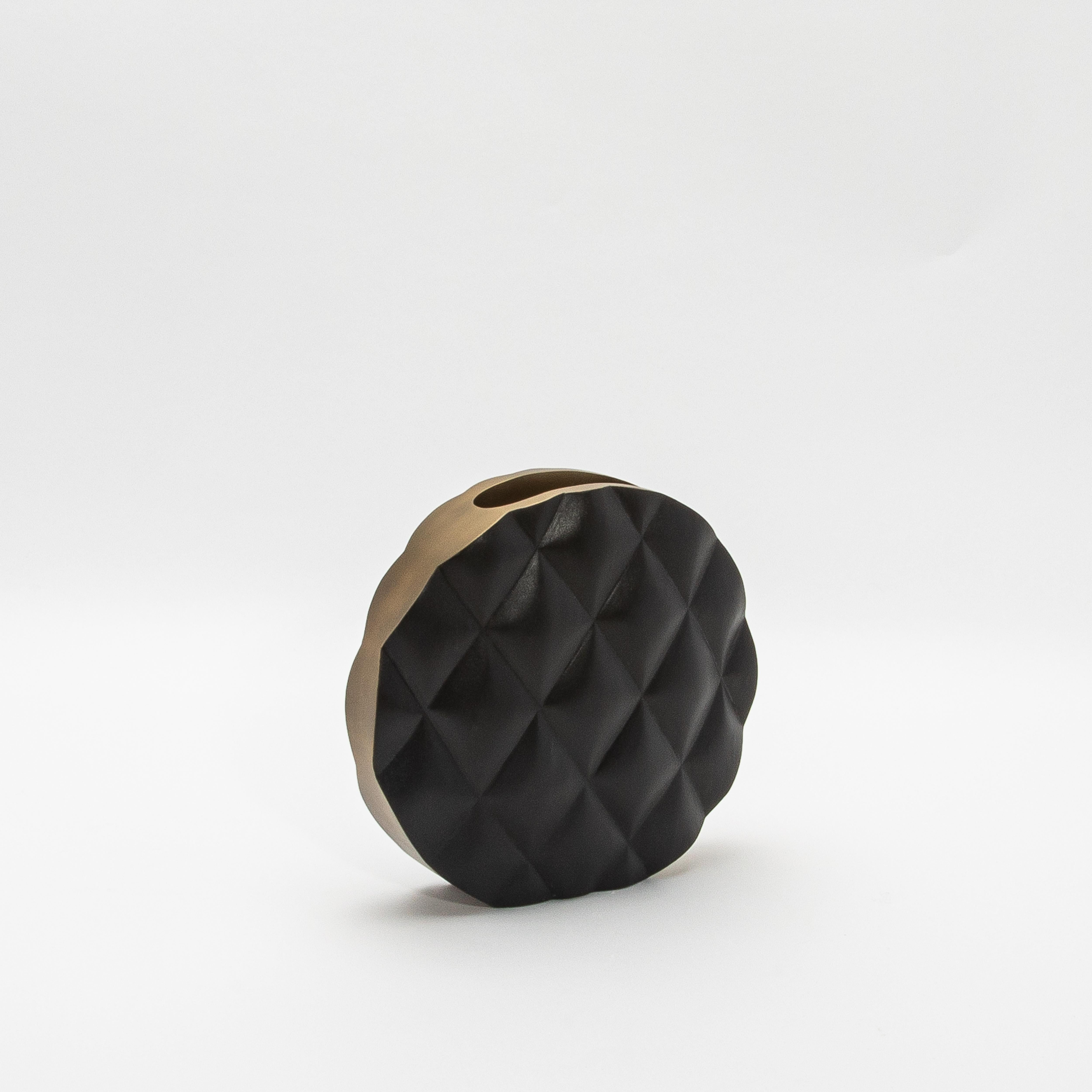 Die Coco Vase von Kifu Paris ist ein exquisites Stück, das mühelos modernes Design mit luxuriöser Handwerkskunst verbindet. Die handgefertigte Oberfläche aus schwarzer Eiche ist mit einer charakteristischen Steppstruktur versehen, die ihm eine