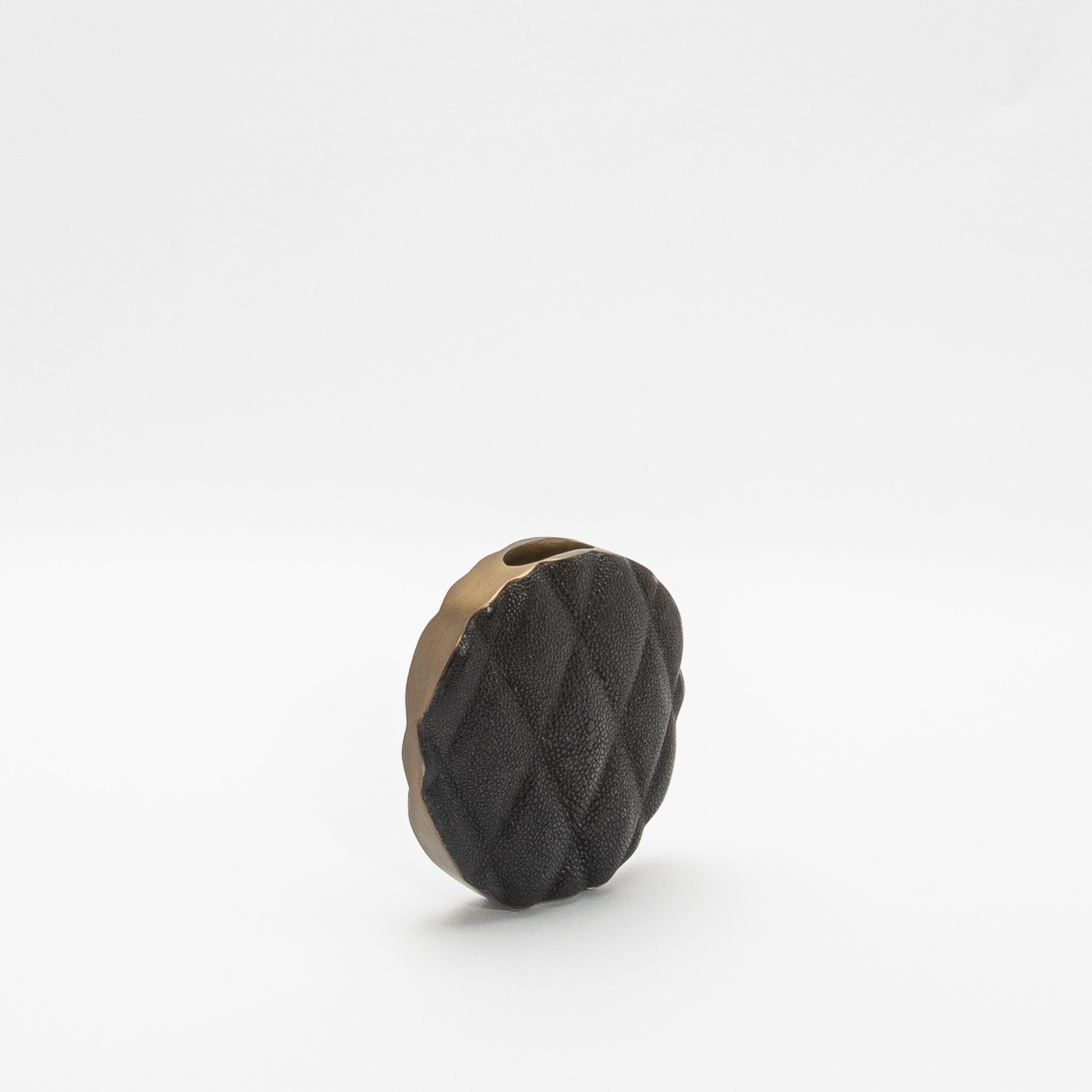 Die Vase Coco von KIFU Paris ist ein Statement, das modernen Luxus und zeitlose Eleganz harmonisch miteinander verbindet. Die Oberfläche der Vase aus kostbarem schwarzem Chagrin ist mit einem auffälligen Steppmuster versehen, das Raffinesse
