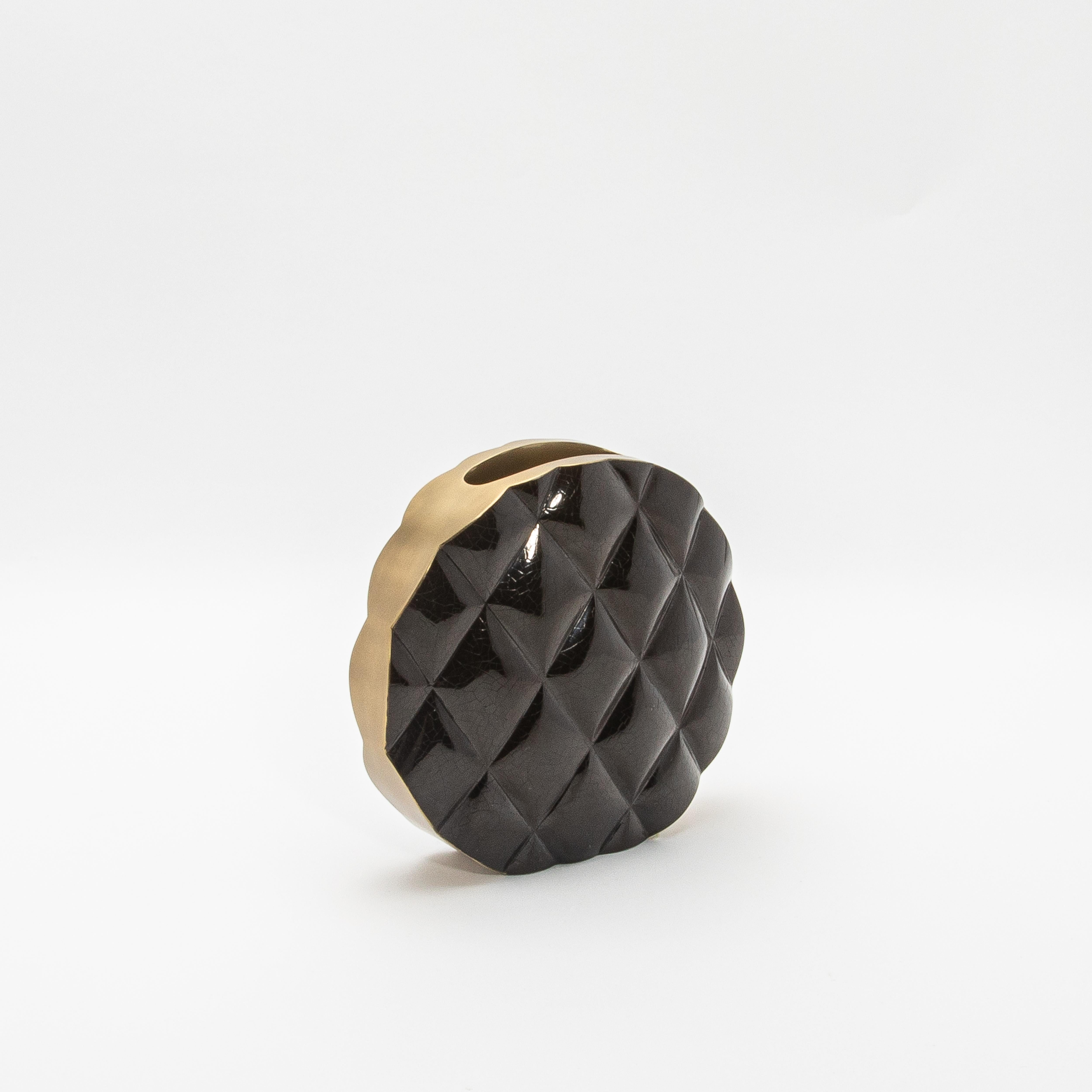 Le vase Coco de Kifu Paris incarne le summum du design sophistiqué avec sa silhouette audacieuse et moderne. Fabriqué en coquillage noir lustré, la surface du vase est méticuleusement matelassée, créant un motif dynamique et tactile qui évoque le