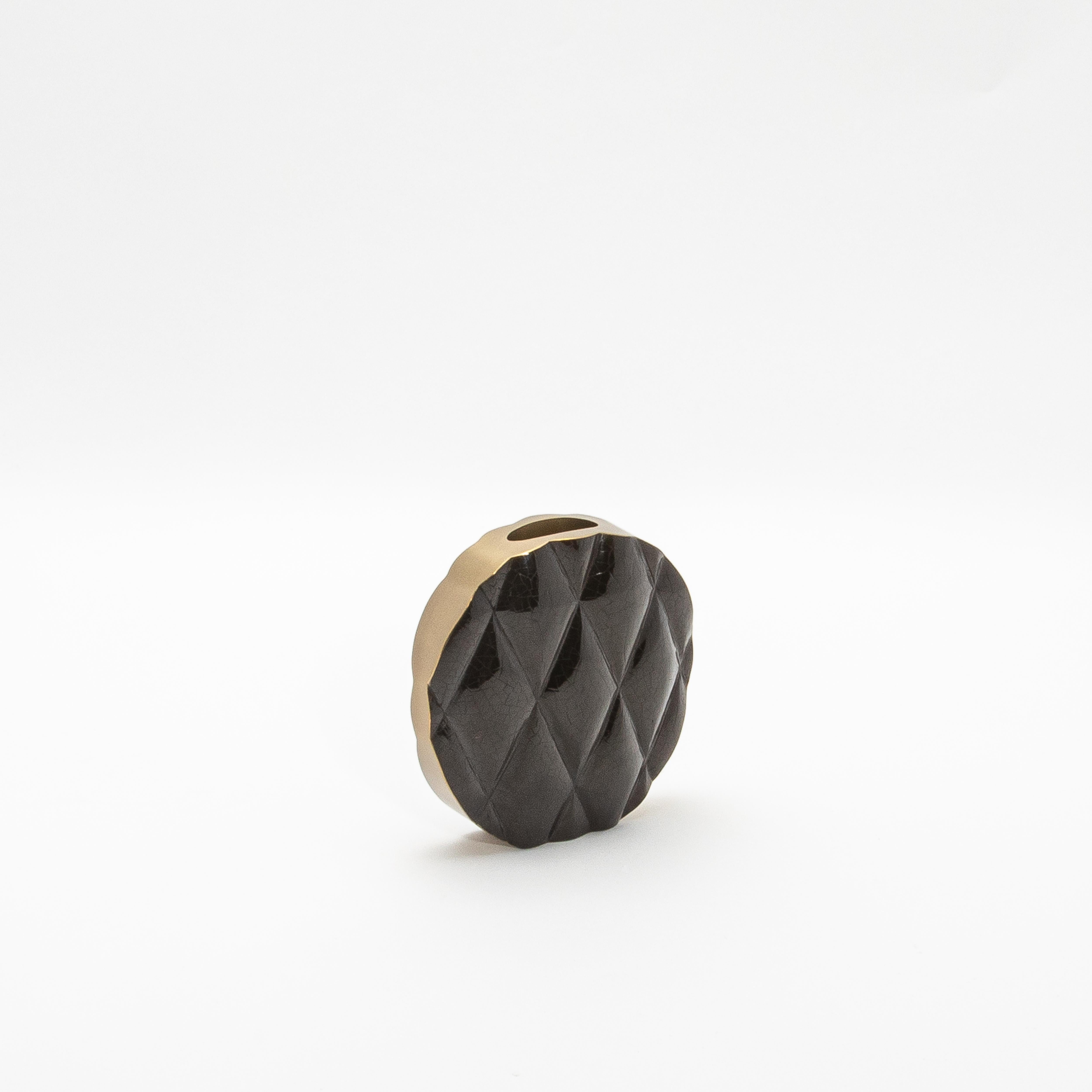 Le vase Coco de Kifu Paris incarne le summum du design sophistiqué avec sa silhouette audacieuse et moderne. Fabriqué en coquillage noir lustré, la surface du vase est méticuleusement matelassée, créant un motif dynamique et tactile qui évoque le