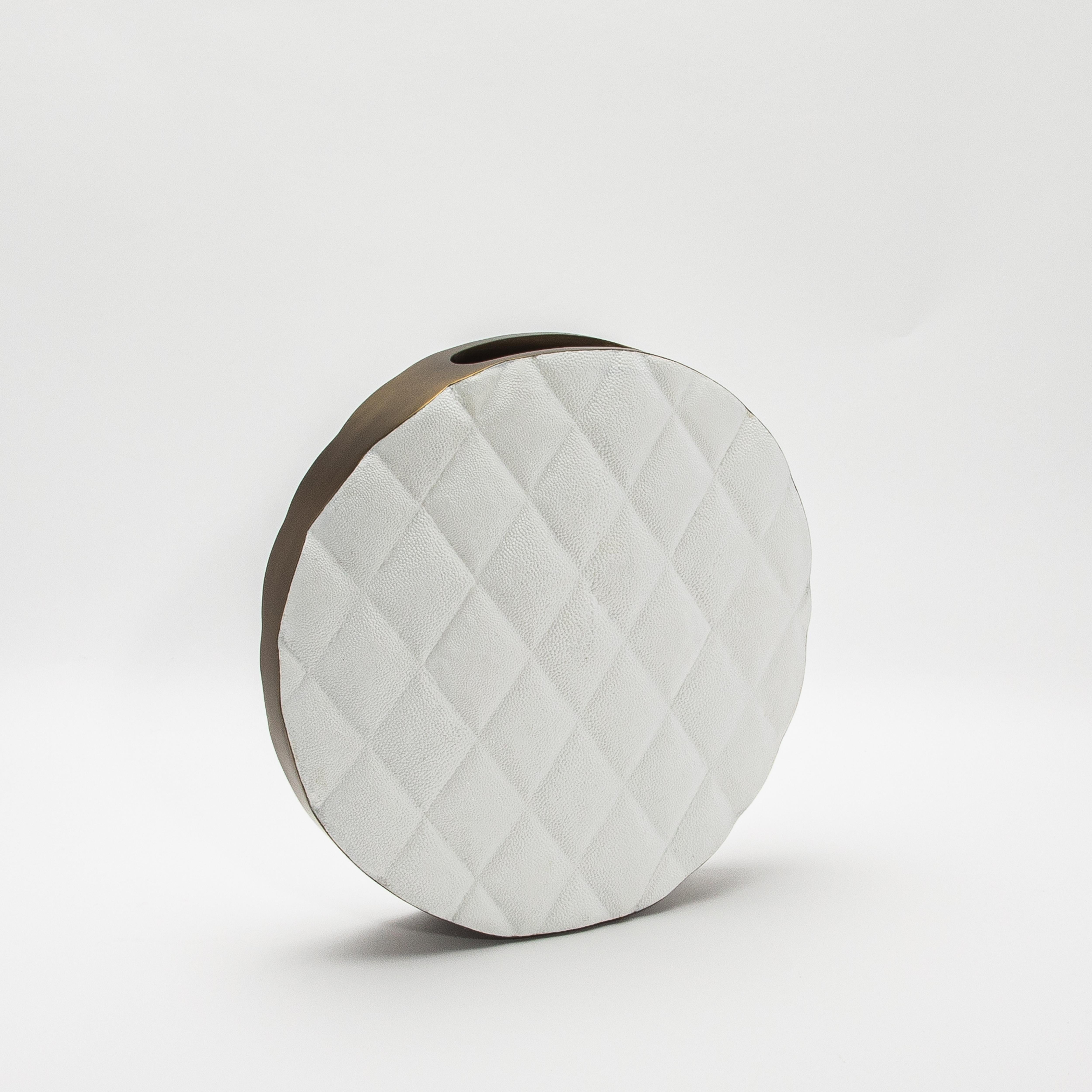 Die Coco Vase von Kifu Paris ist ein Statement, das modernen Luxus und zeitlose Eleganz harmonisch miteinander verbindet. Die Oberfläche der Vase aus prächtigem weißem Chagrin ist mit einem auffälligen Steppmuster versehen, das Raffinesse