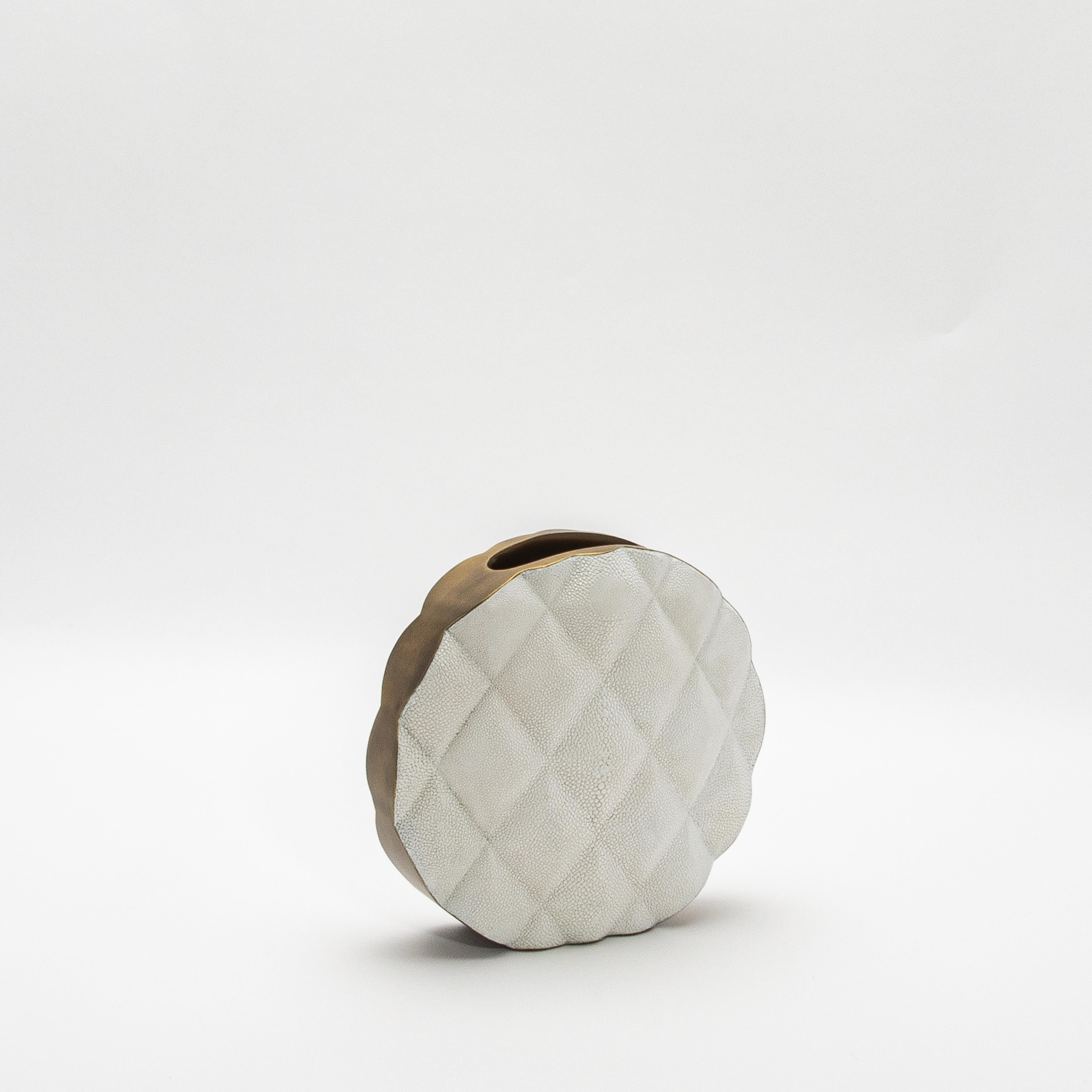 Die Vase Coco von KIFU Paris ist ein Statement, das modernen Luxus und zeitlose Eleganz harmonisch miteinander verbindet. Die Oberfläche der Vase aus prächtigem weißem Chagrin ist mit einem auffälligen Steppmuster versehen, das Raffinesse