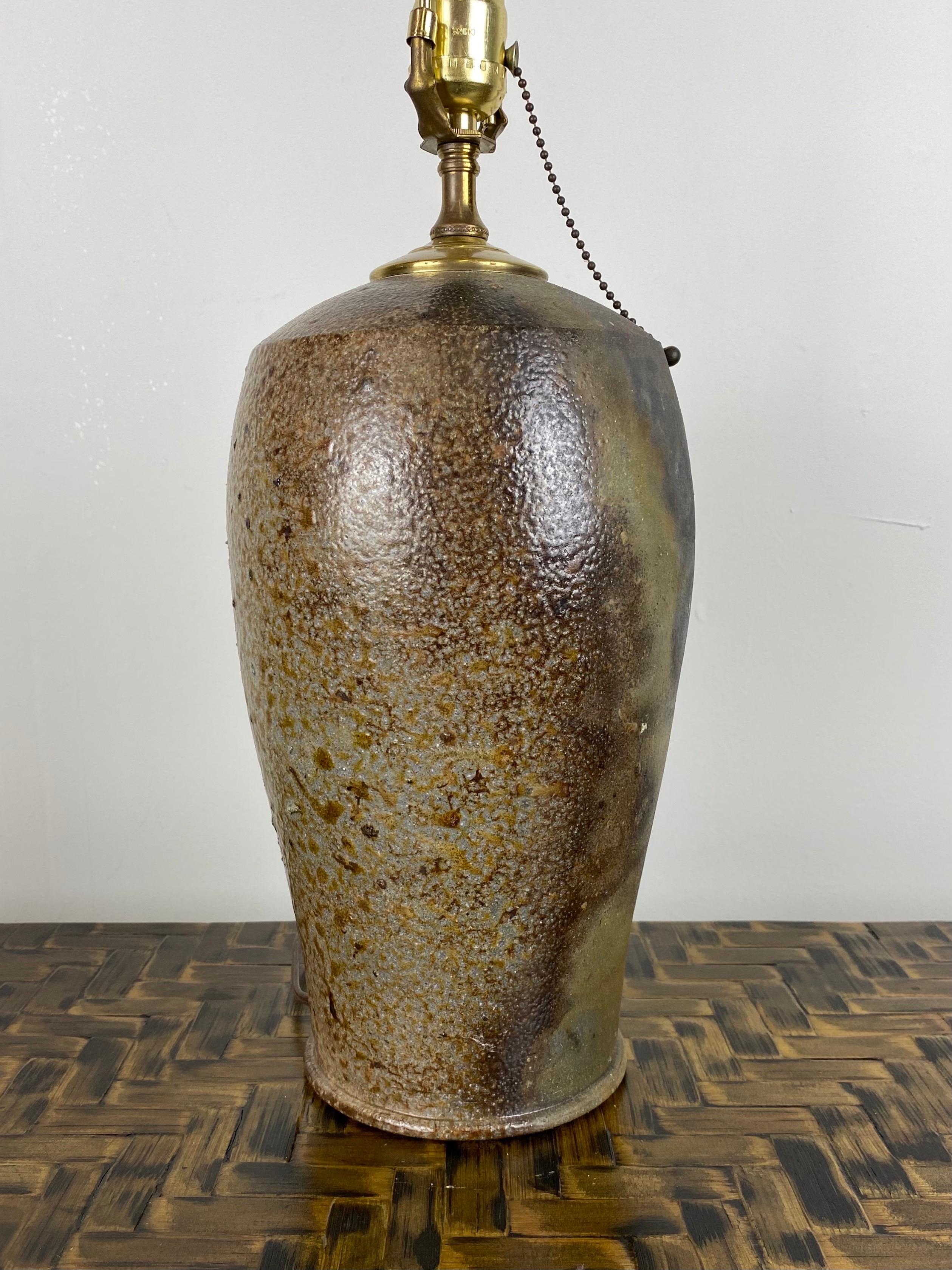 This unique pottery table lamp has beautiful earth tones throughout. Highlights of green and grey with some gloss and some matte finish offer great depth to this piece.