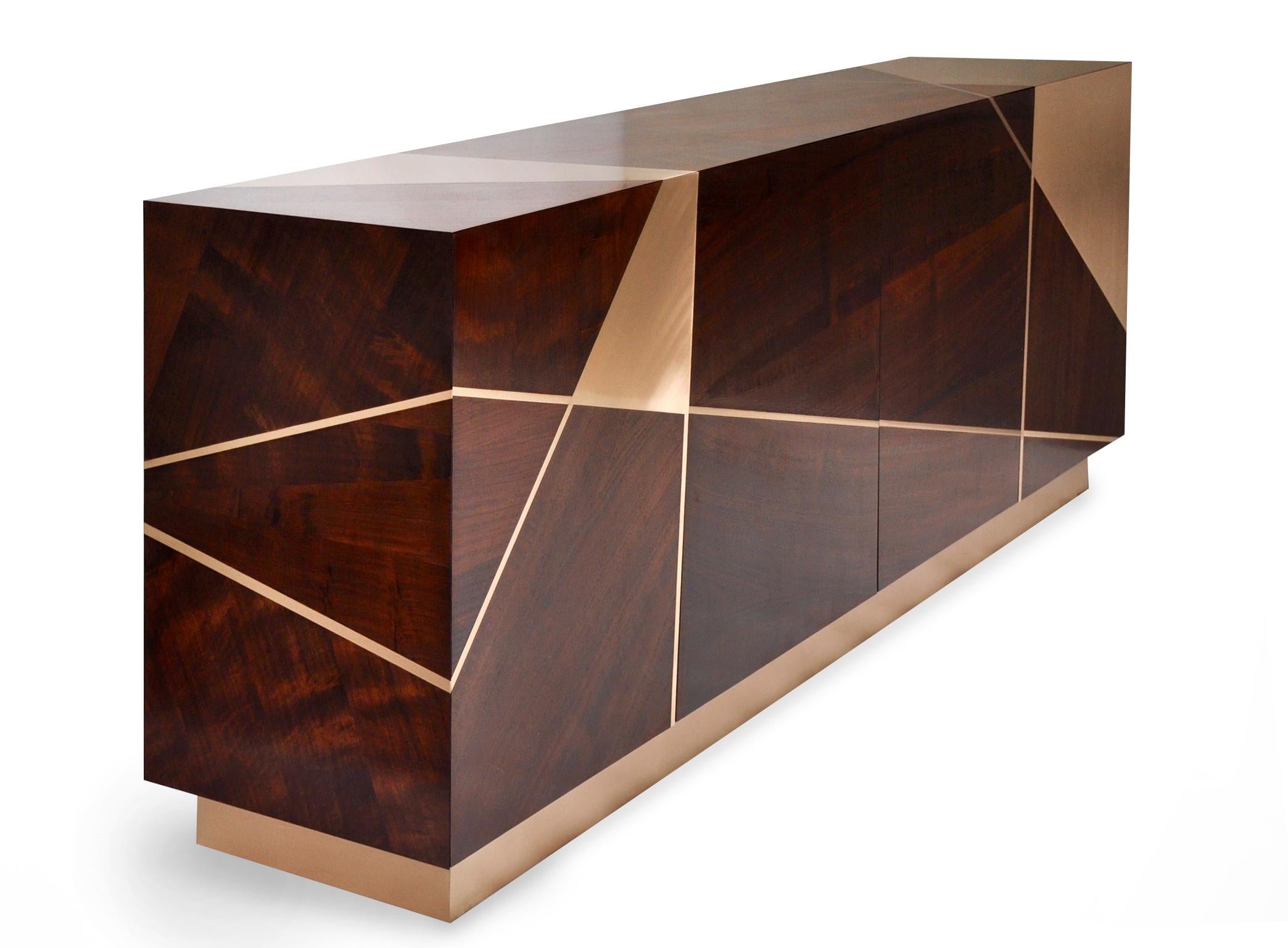 The Ray cabinet in Analine dyed Claro Walnut and Bronze with a bronze base demonstrates an elegant use of the Ray design, walnut, and bronze. A bronze panel wraps the uppermost front corner of the cabinet. The bronze clad corners add to the beauty,