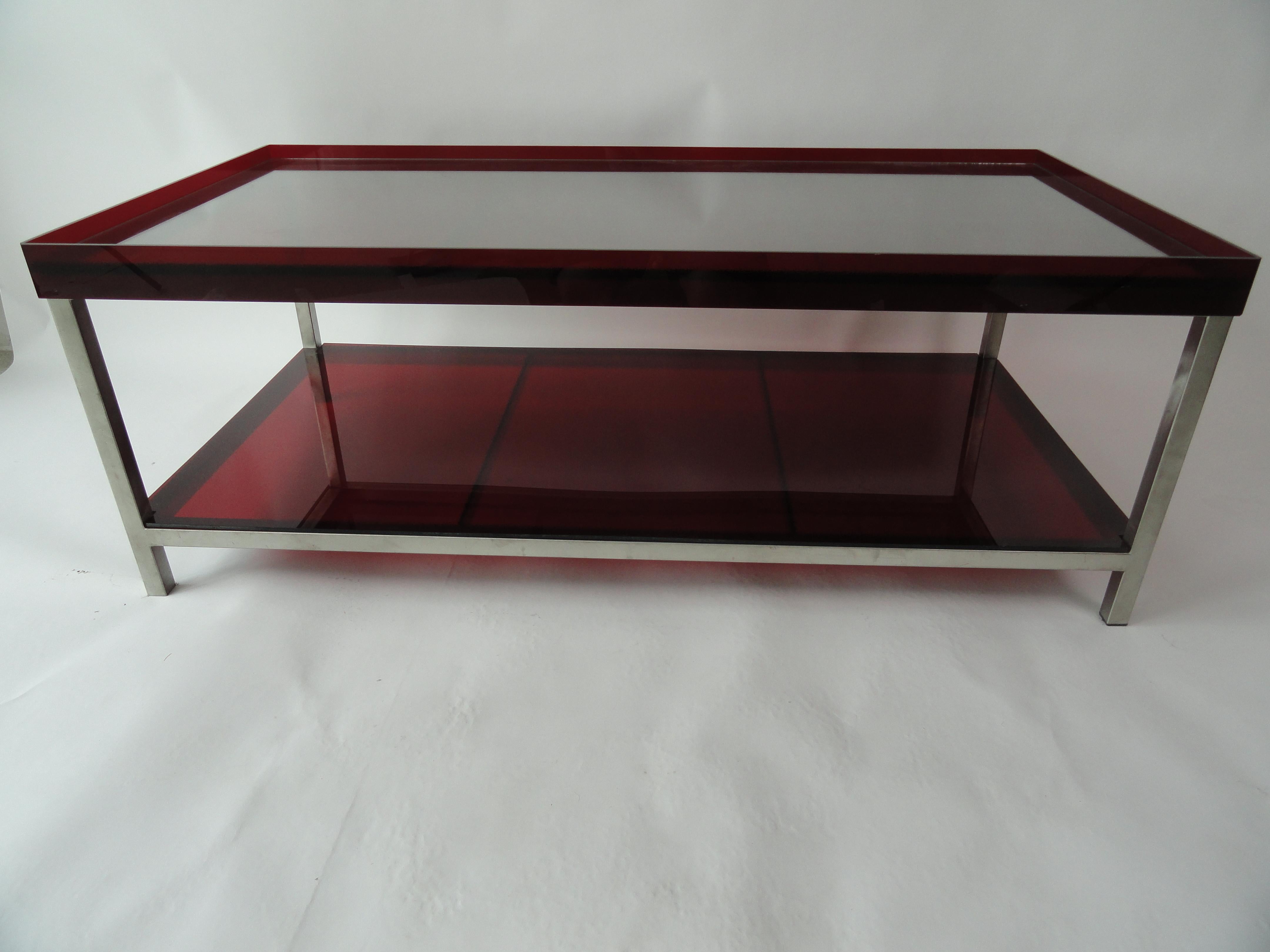 Modern brushed steel coffee table with red acrylic tray top and red acrylic lower shelf. Top has a glass insert to protect the acrylic top from scratching.