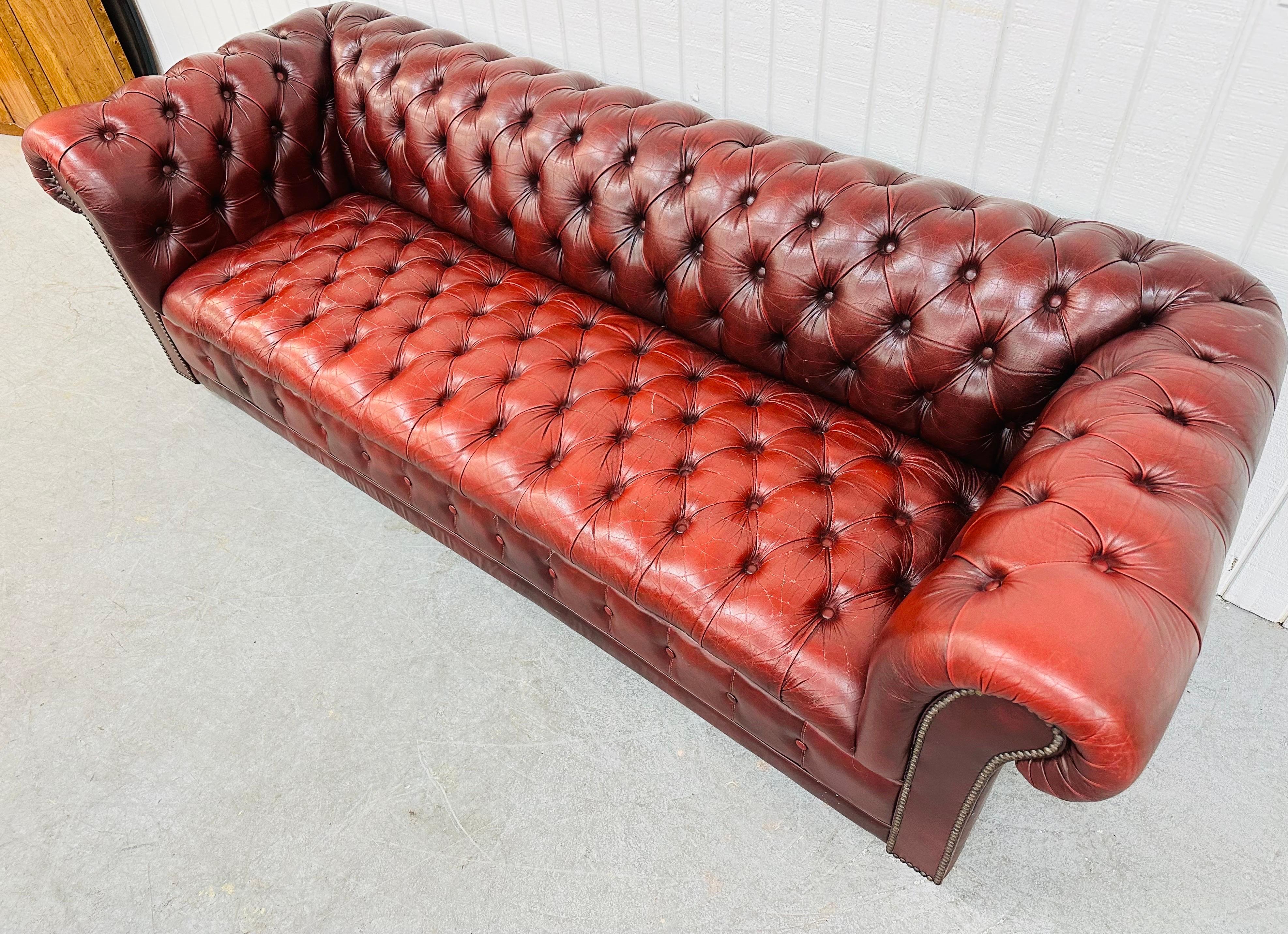 This listing is for a Modern Red Chesterfield Sofa. Featuring an iconic tufted button chesterfield style, a beautiful dark red leather upholstery, nailhead accents, and bun feet. This is an exceptional combination of quality and design!