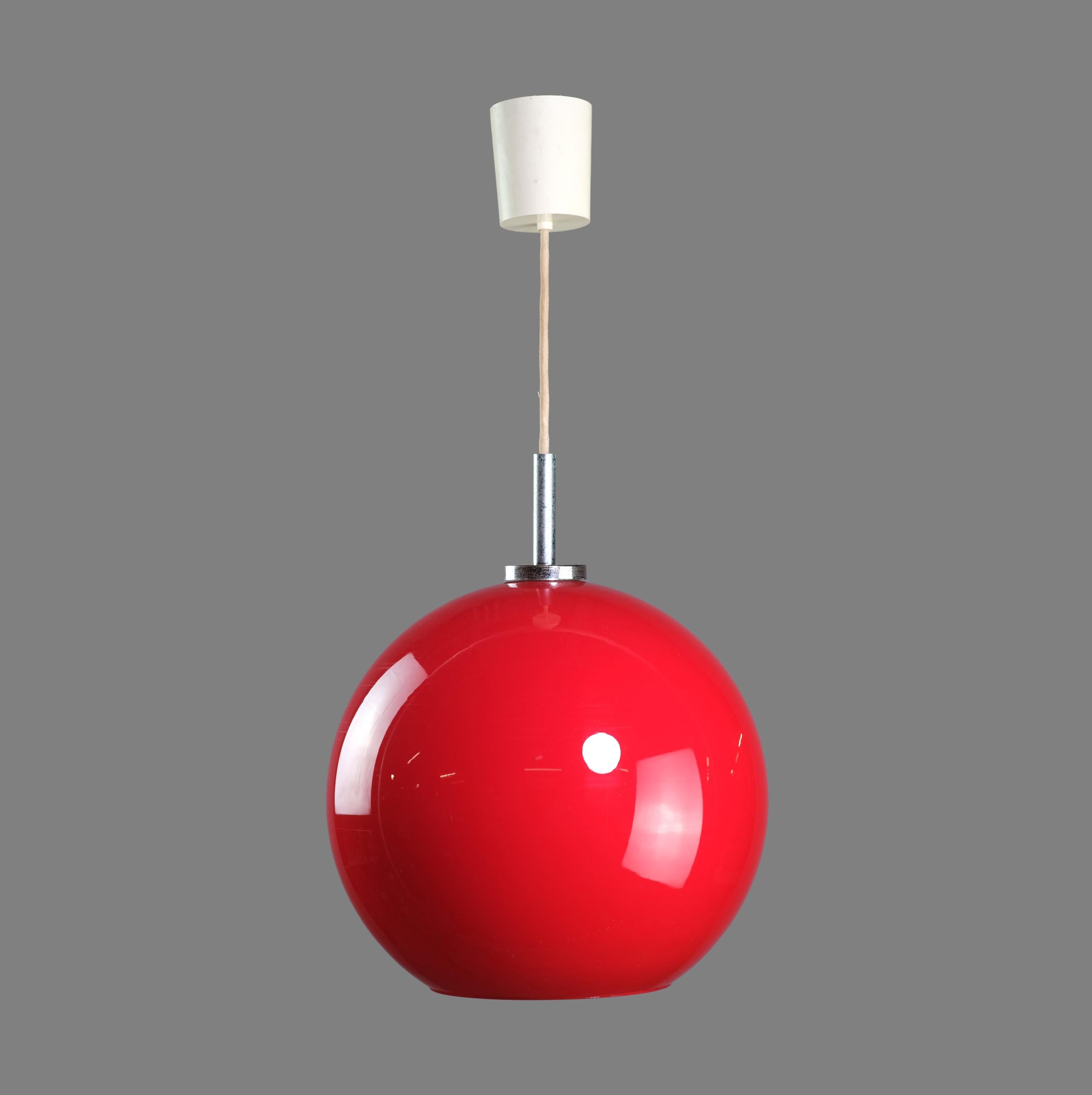 Mid-20th century pendant light from Europe. Features a red opaline sphere shade, fabric covered cable and white plastic ceiling canopy. This can be seen at our 400 Gilligan St location in Scranton, PA.