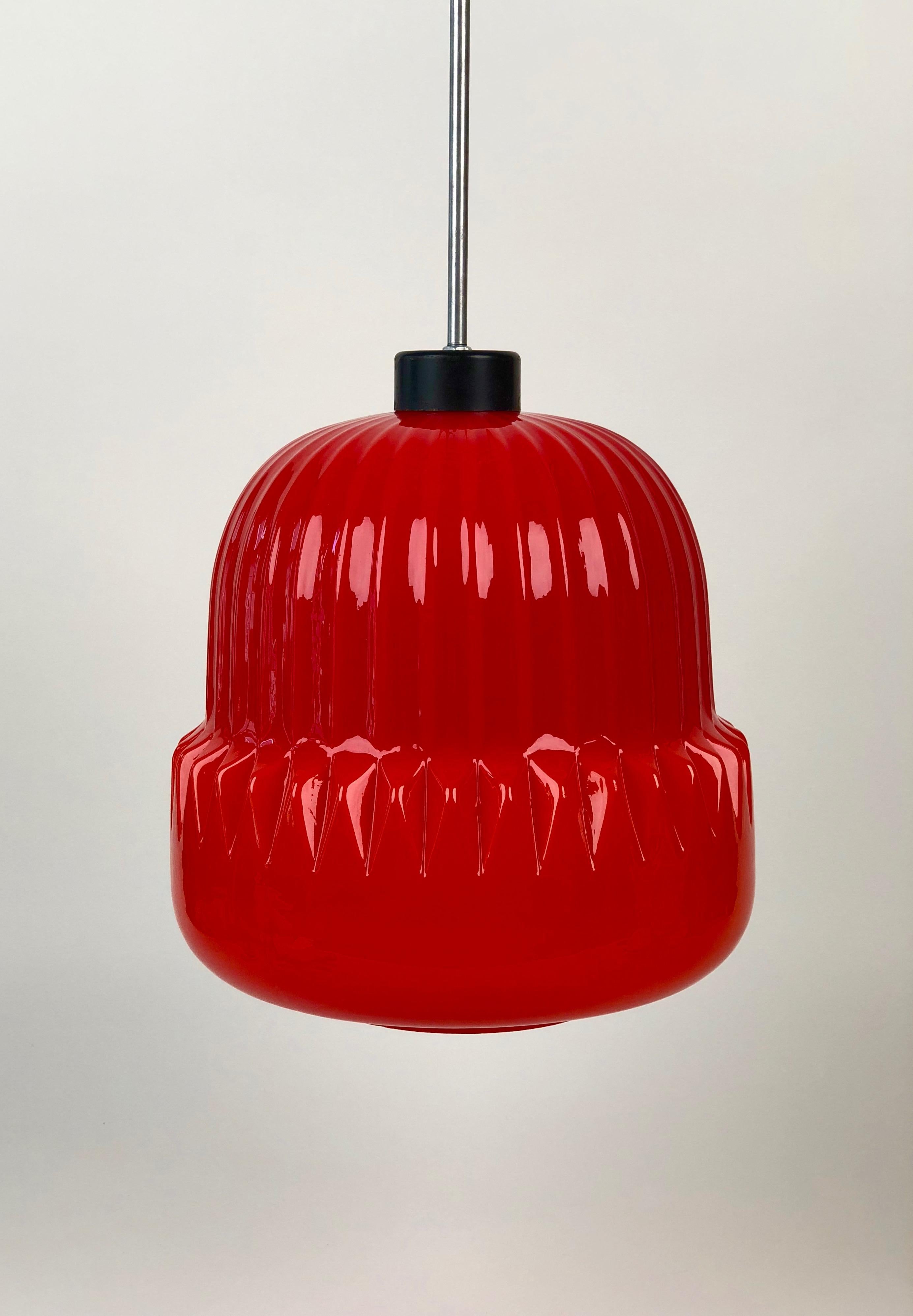 Une lampe suspendue très unique du début des années 1960, fabriquée en Tchécoslovaquie. L'abat-jour en verre rouge a un
motif cannelé moulé dans la forme du verre. La lumière émise est chaude et intense. Il brille. J'espère...
que j'ai obtenu une