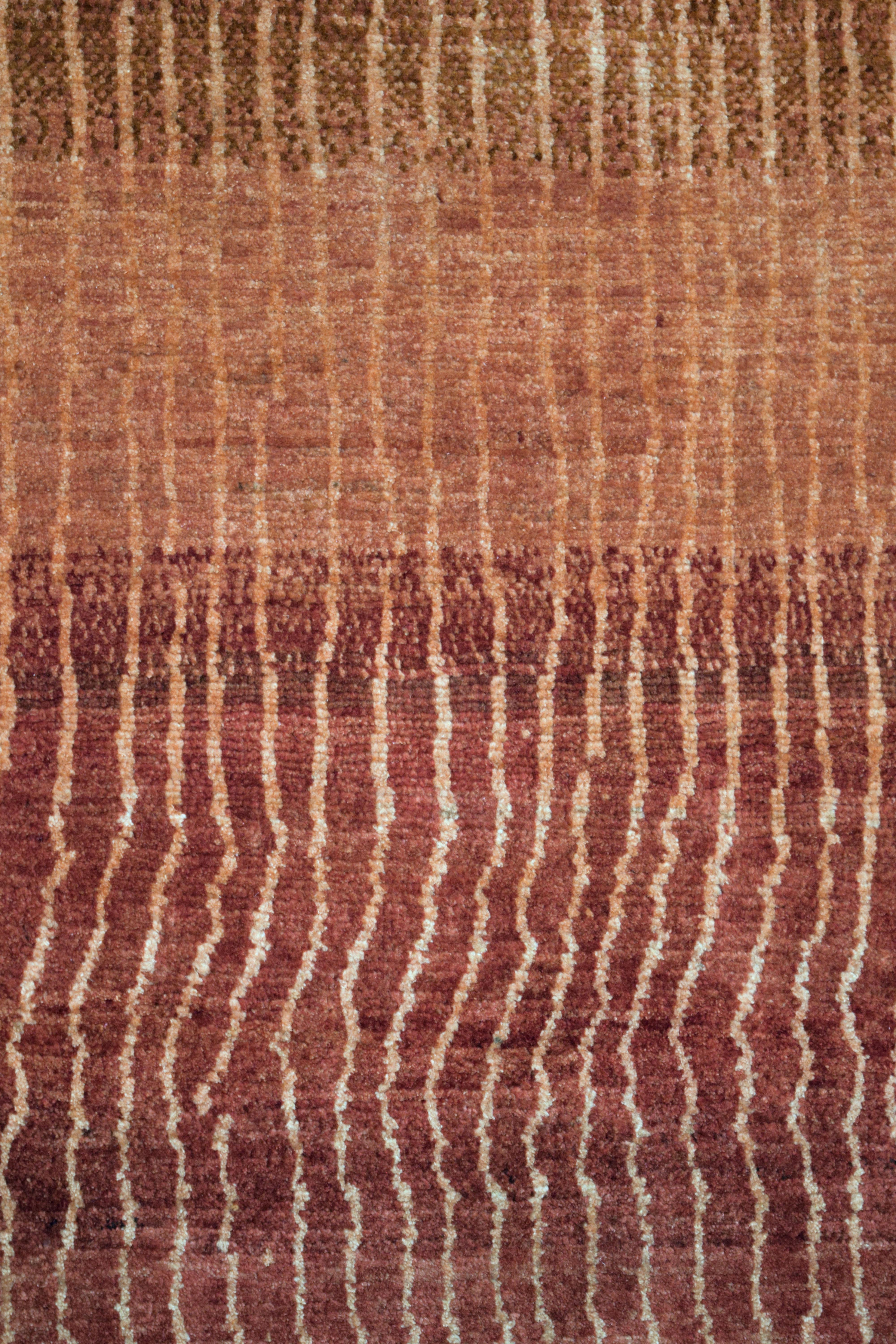 This modern red ombre wool Persian rug, sized 3' x 5', captivates with its textured waves, creating a visually dynamic effect. The rug features a rich gradient of red hues that seamlessly flow across its surface, enhanced by the natural striation