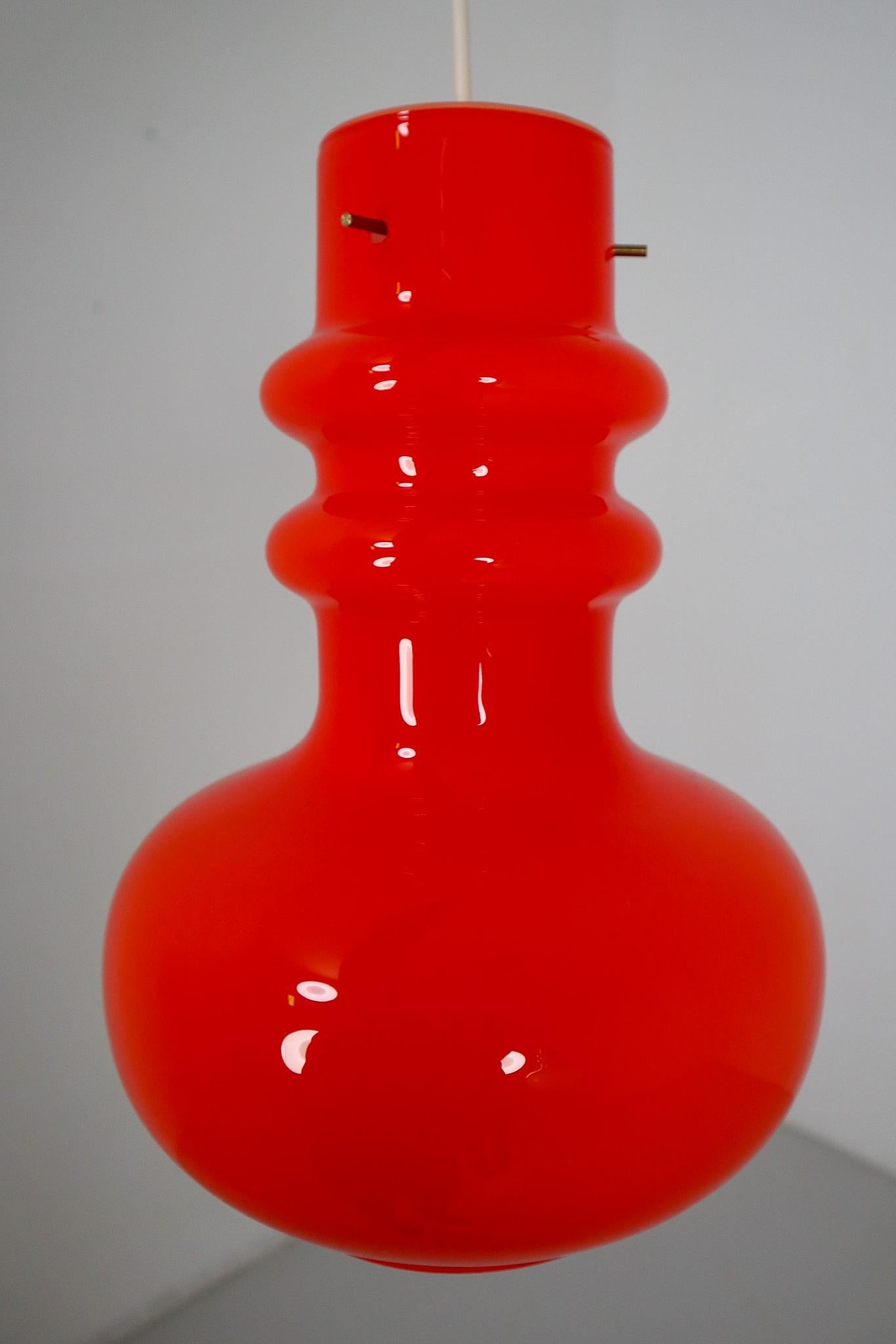 Modern opaline glass pendant lamp Italy 1970s. The diffuse light it spreads is very atmospheric. Completed with the red opaline glass and small brass details, these pendants will contribute to a luxury/modern character of the (hotel-bar-restaurant)