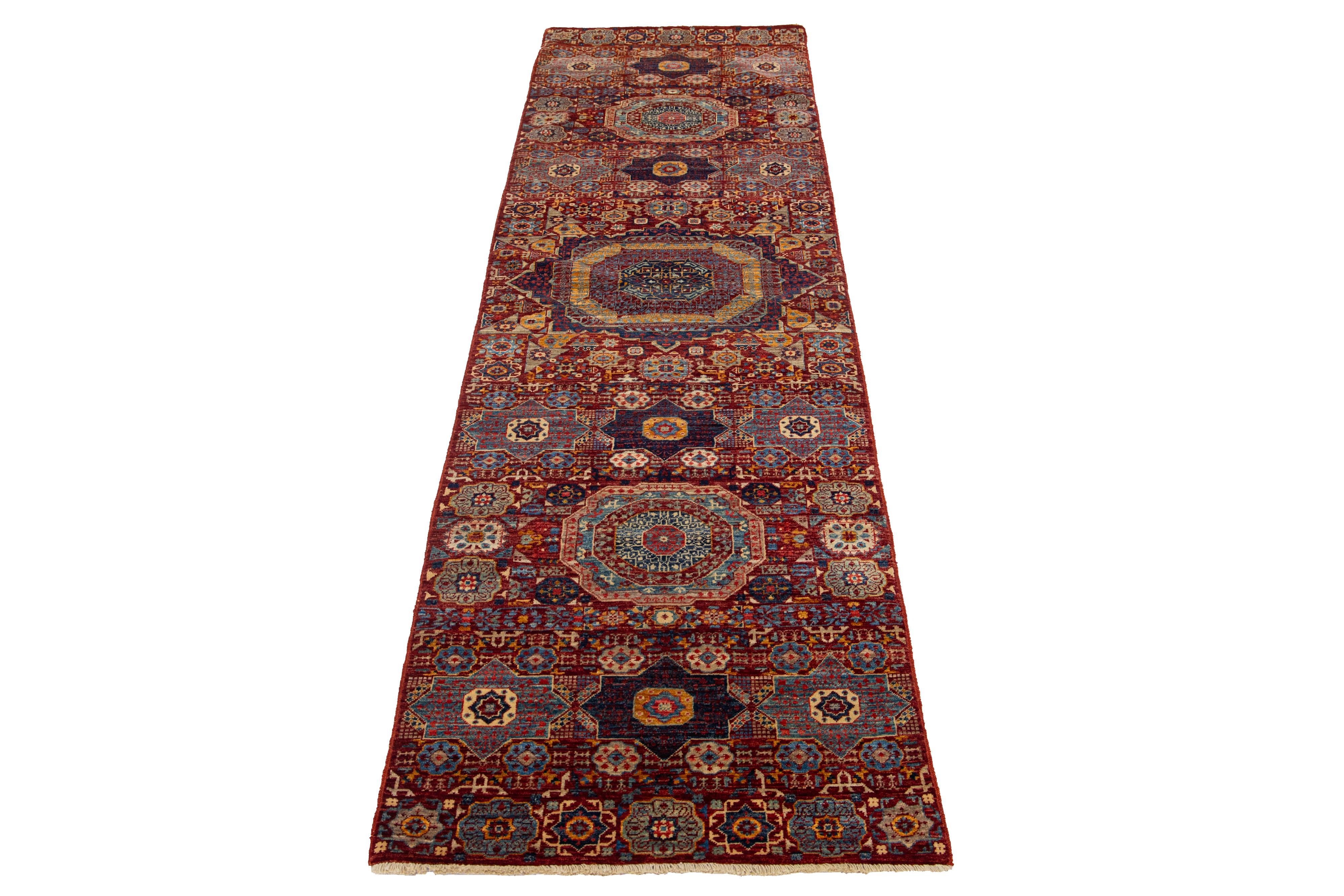 Beautiful modern Transitional hand-knotted wool runner with a red field. This Piece has blue, beige, and yellow accent colors in a gorgeous all-over geometric floral design.

This rug measures 2'9