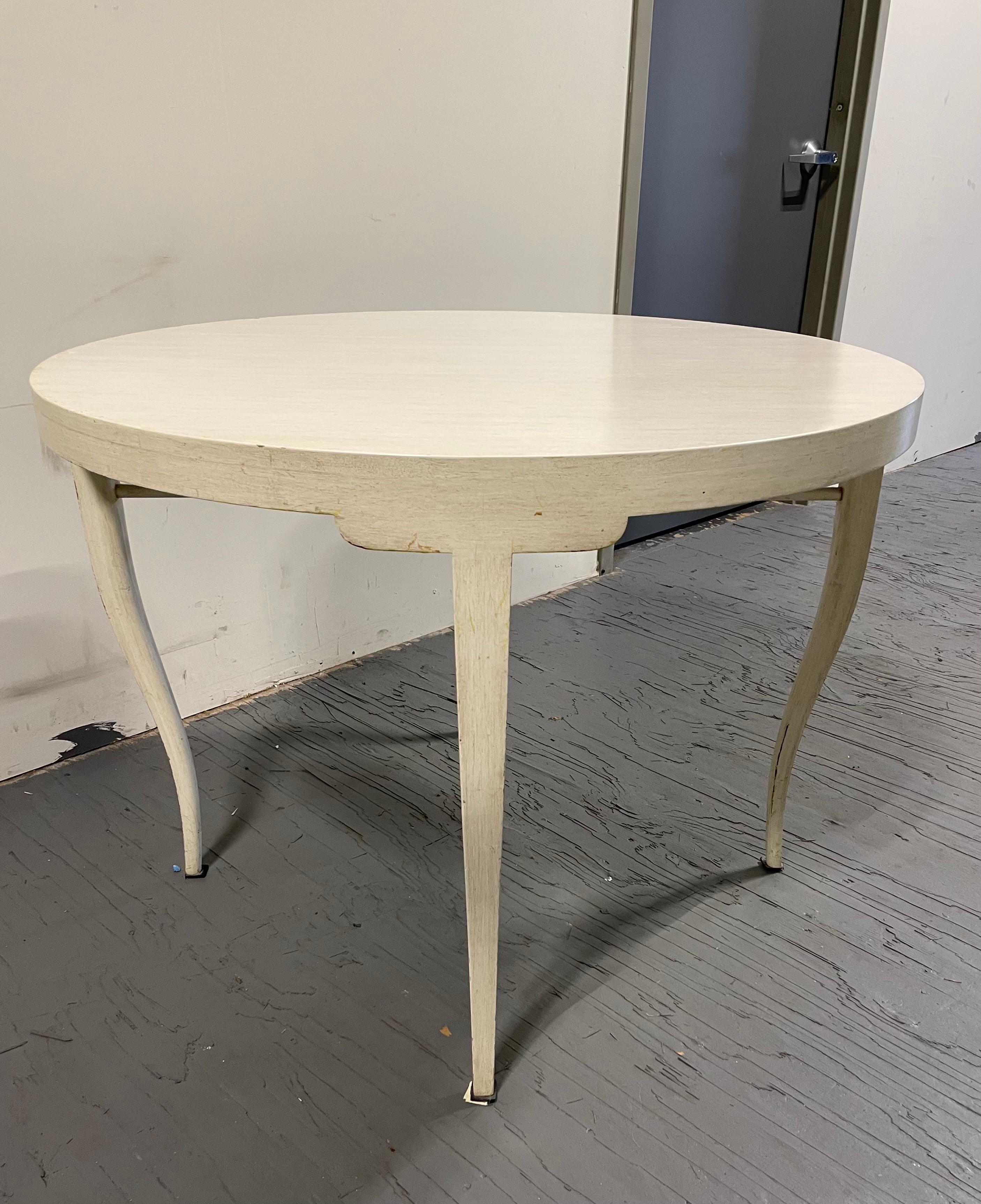 Wonderful sleek and glamorous lines in this game or dining table in the style of Tommi Parzinger. Curvy cabriole legs and underside cross stretcher. White finish in a washed or cerused manner. Table came from an estate that used as a game table with