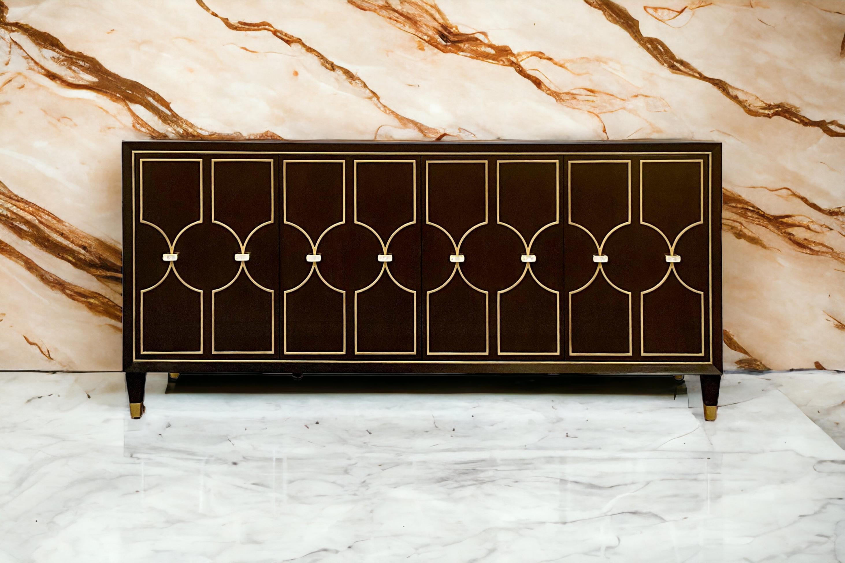 This is a beautiful modern regency style credenza by Lexington Furniture. It is no longer in production and is part of the Carlyle Collection. The piece is a mix of walnut and mahogany veneers with an espresso finish. It opens to shelves. The