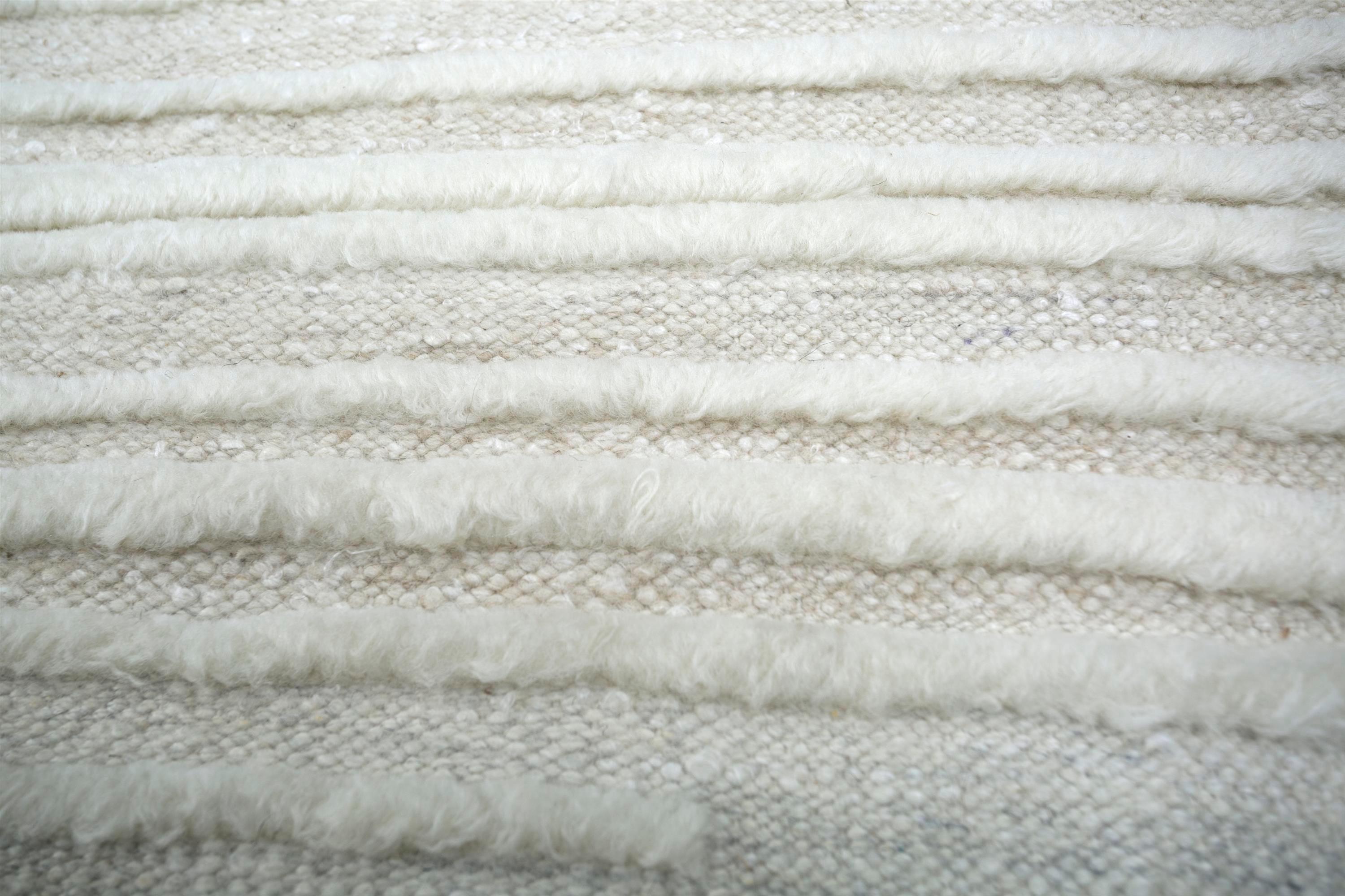 Embrassez l'essence de l'élégance intemporelle avec une touche de charme inattendu. Ce tapis noué à la main incarne l'équilibre parfait entre design classique et innovation moderne. Son fond blanc non teinté, qui rappelle la neige fraîchement