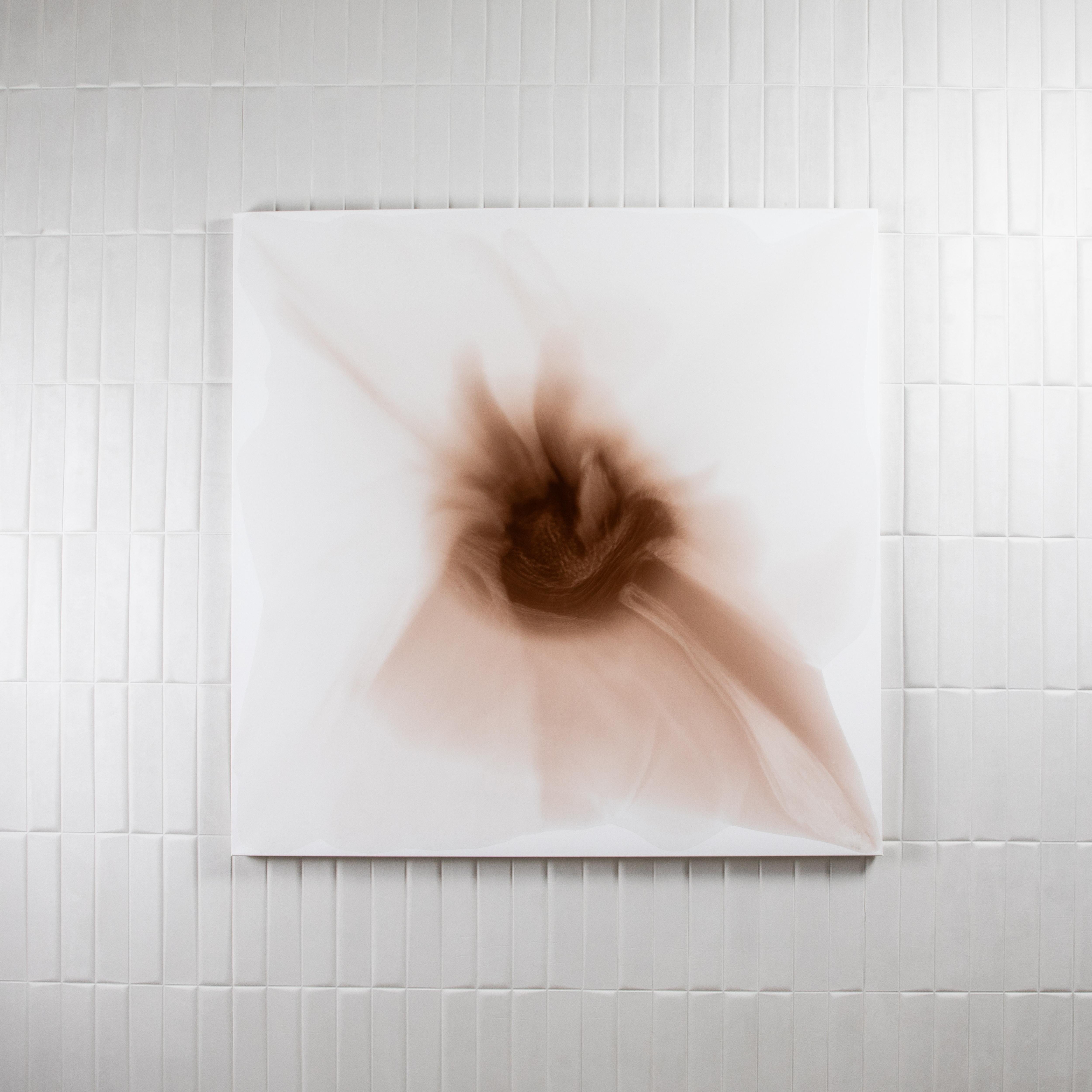 Dieses Kunstwerk aus der Serie e-the-re-al taucht den Betrachter in ein weiches, rauchiges Sepia ein - eine Palette, die Wärme, Intimität und Ruhe ausstrahlt. Tinte und Harz fließen auf der Leinwand zusammen und schaffen eine abstrakte Blüte, die