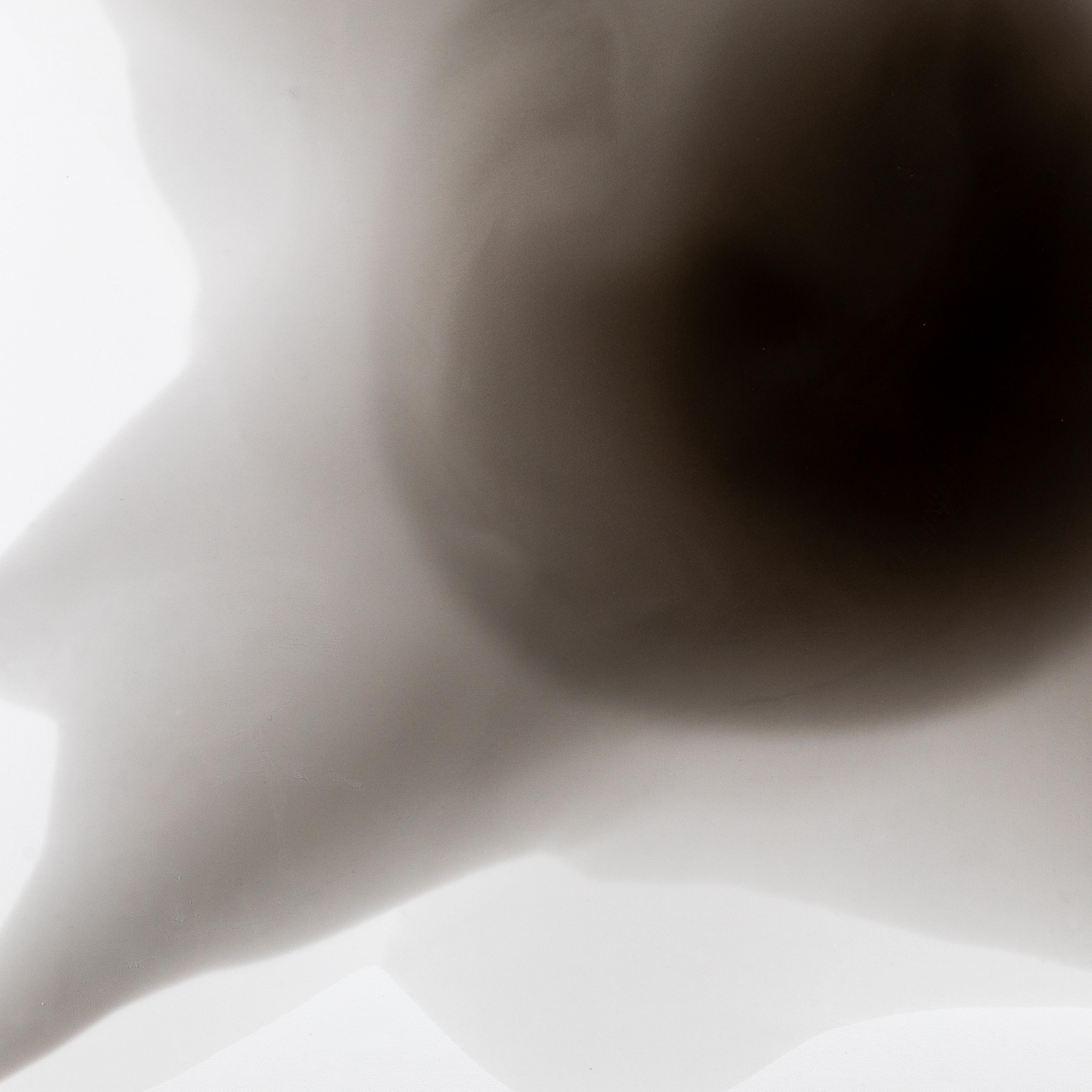 Dalla serie e-the-re-al, questa composizione monocromatica offre una serenità ammaliante, che si dispiega in strati fumosi di grigio e nero morbido. Creata con inchiostro e resina su tela, la sua forma organica sembra irradiare da un nucleo