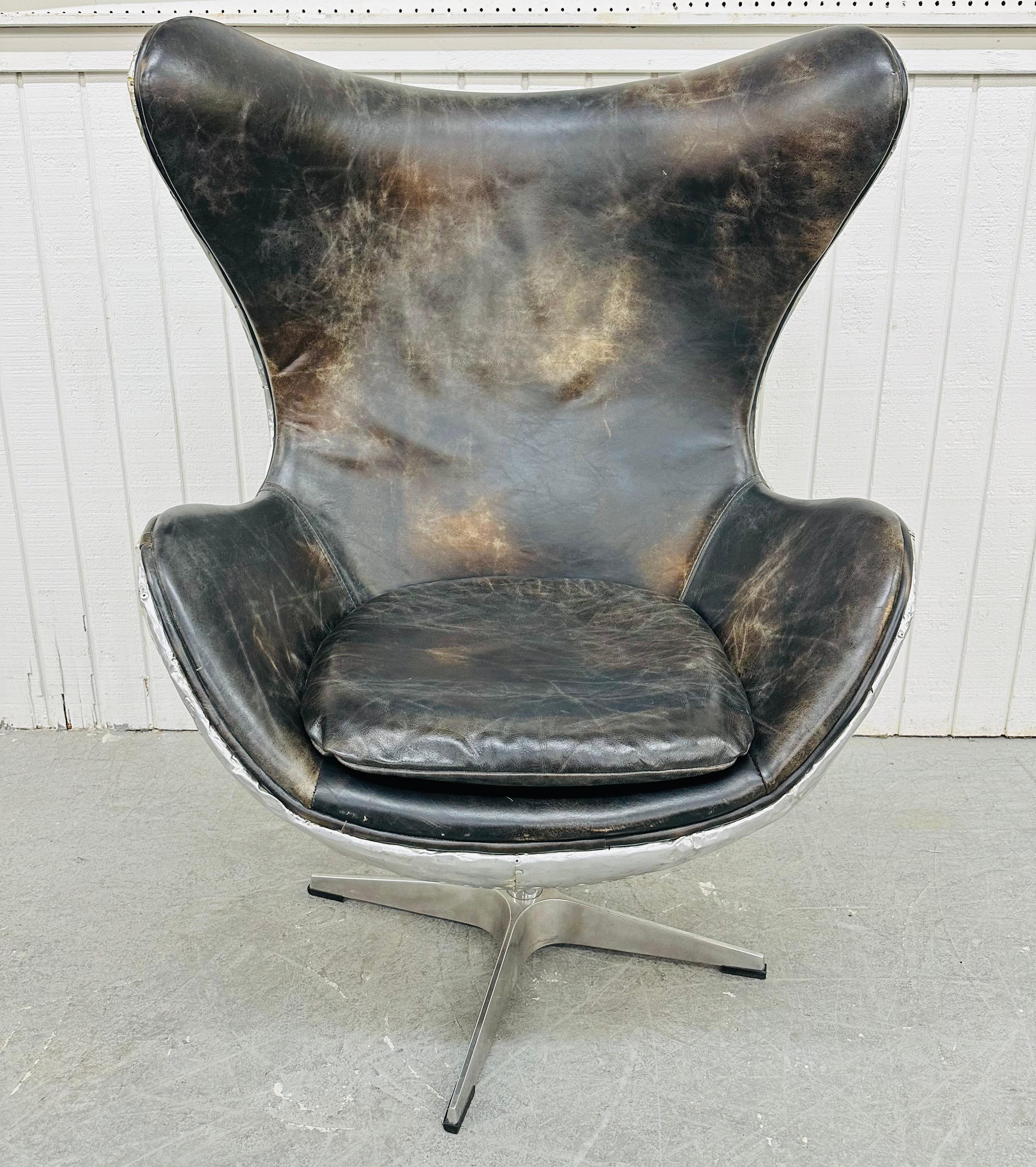 This listing is for a Modern Restoration Hardware Aviator Swivel Egg Chair & Ottoman. Featuring an egg shaped wing chair, metal aviator style, brown leather upholstery, and chrome modern legs with swivel mechanism. Also, the matching leather ottoman.
