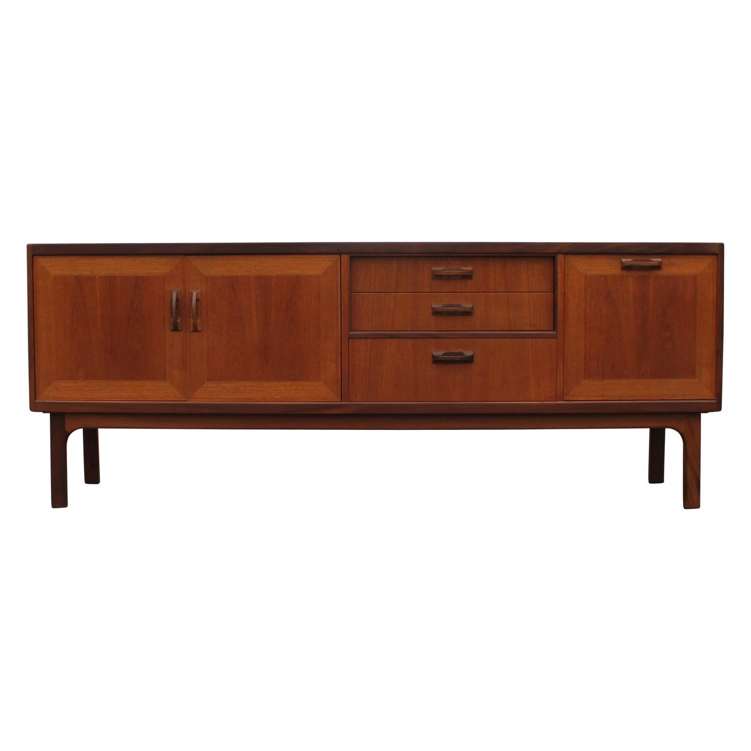 Modern restored teak credenza with a lovely walnut finish by G Plan Furniture. This piece has a cabinet space on the left with a single shelf, three drawers in the centre and a drop door on the right.