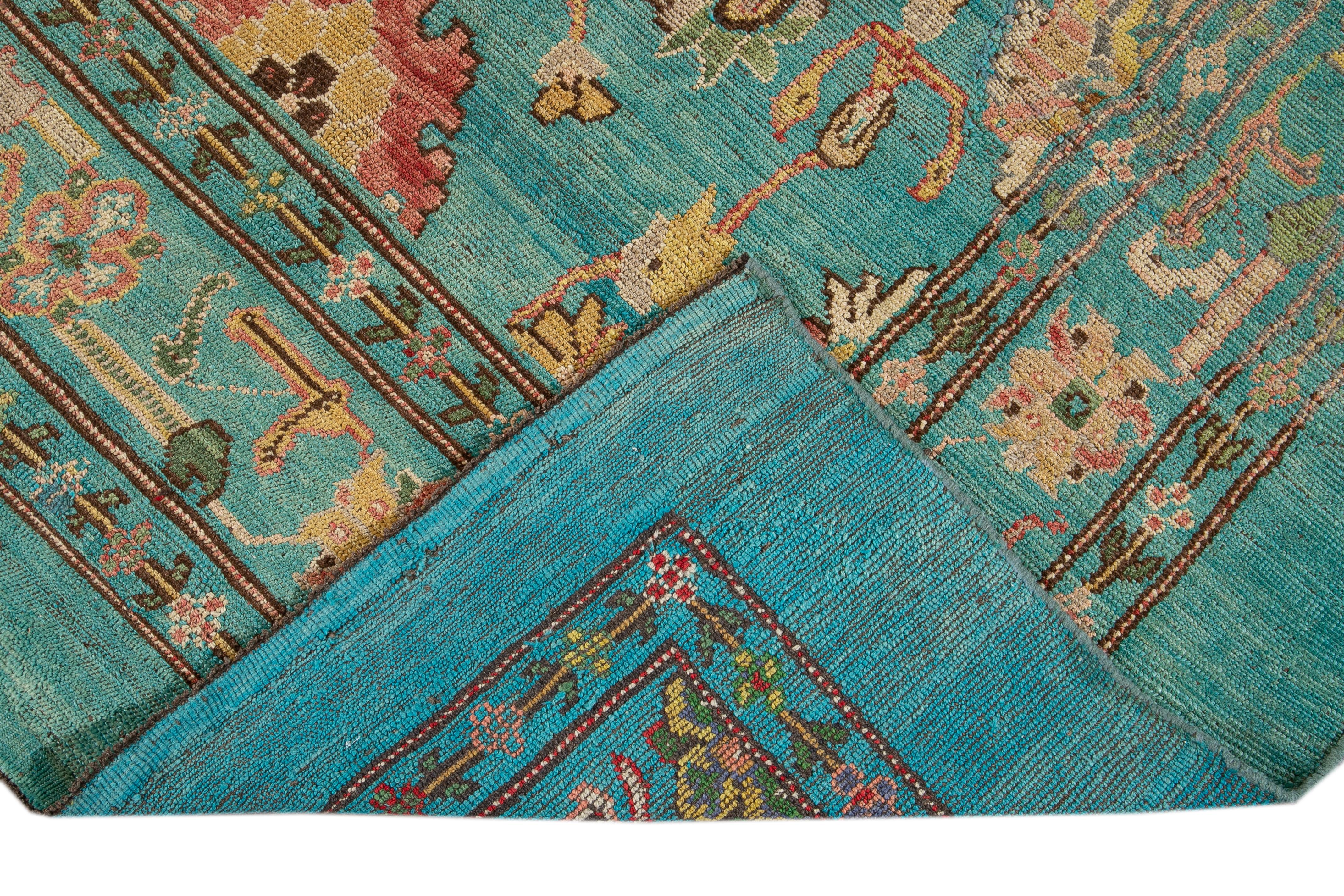 Beautiful modern hand-knotted wool rug with a blue field. This Revival Collection rug has yellow, pink, brown, and green accents all-over a gorgeous geometric Botanical Floral design.

This rug measures 7' x 9'4