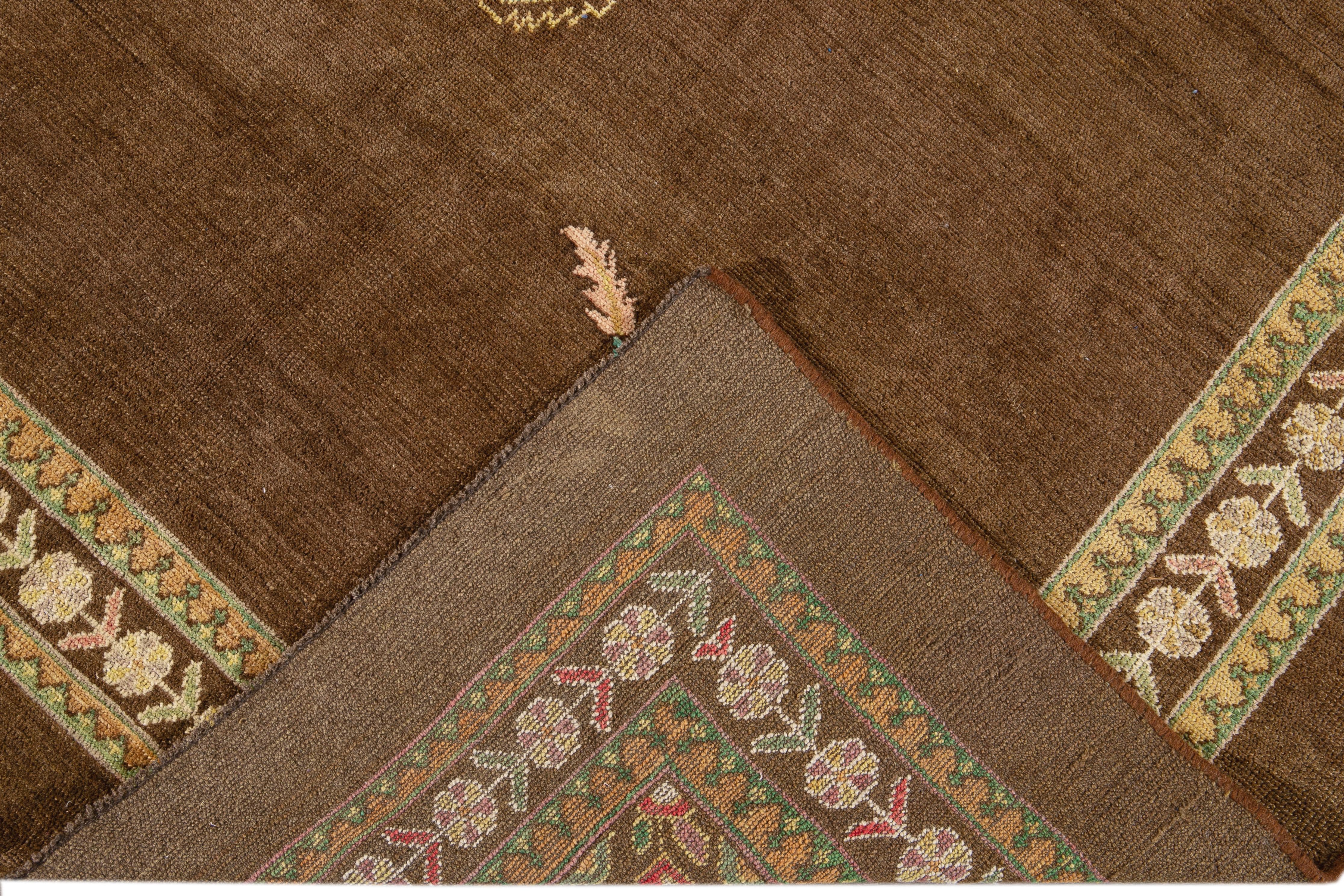 Beautiful Modern hand-knotted wool rug with a brown field. This Revival Collection rug has blue, pink, yellow, and green accents all-over a gorgeous geometric medallion Floral design.

This rug measures 6'9