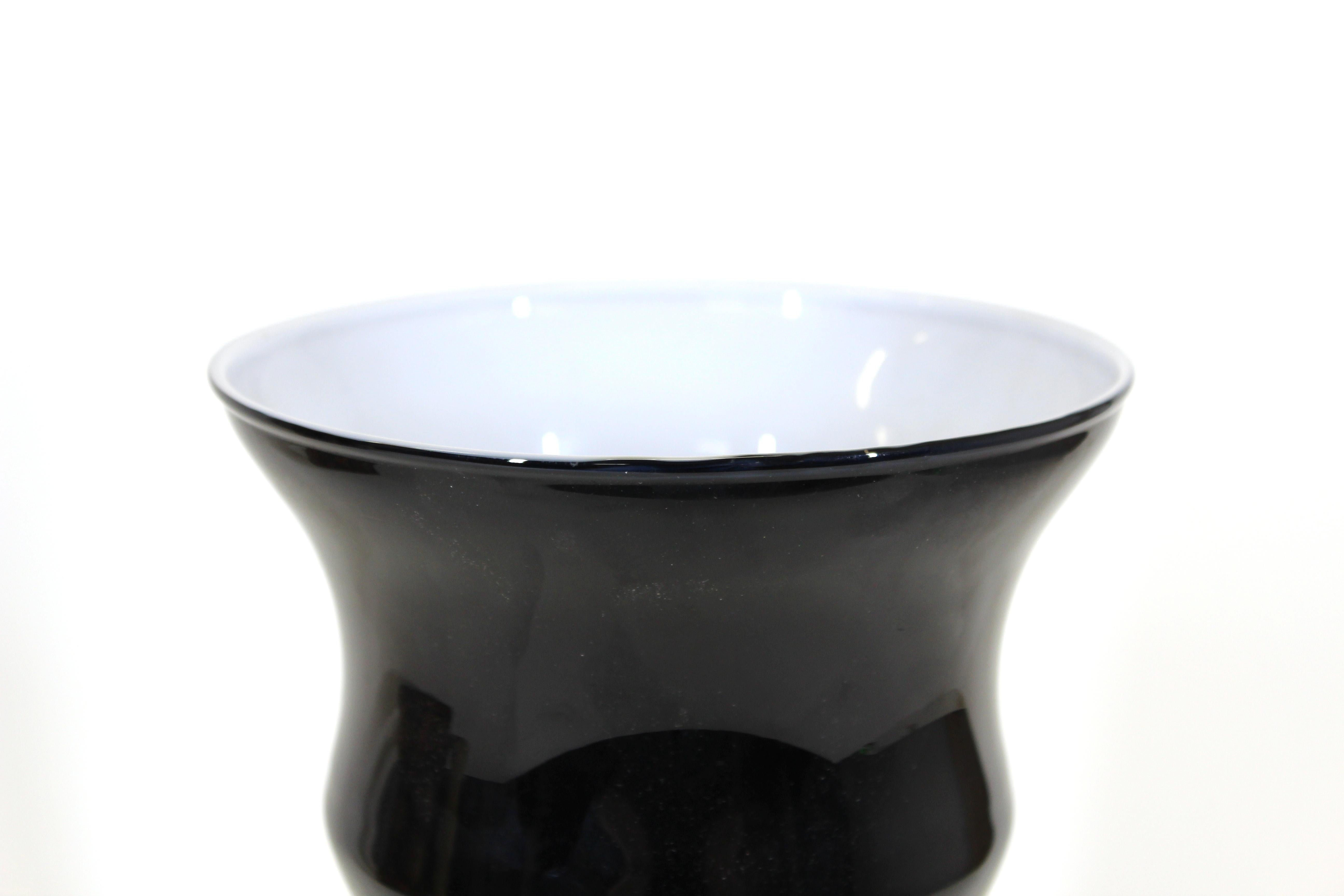 Modern ribbed glass vase in black outer glass and white inner glass.