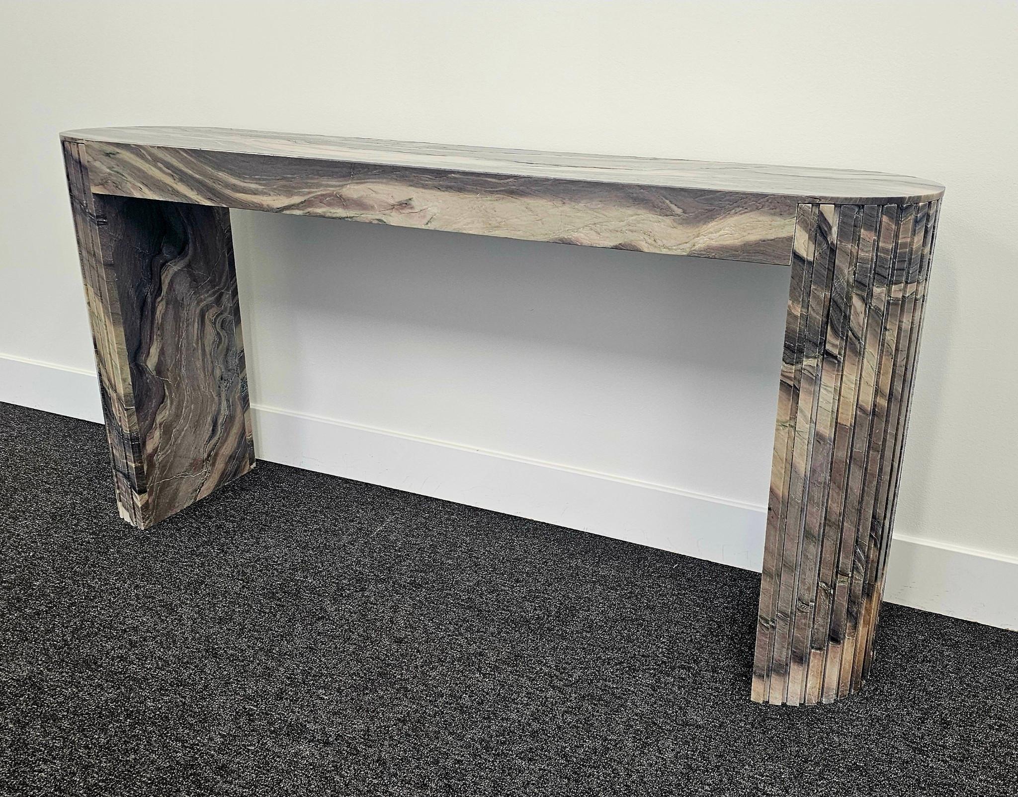 This modern console table is in a stunning Explosion Blue Quartzite. A contemporary twist on the conventional console table design, this table features two half-round legs, each with squared ridges running the height of the table. The Explosion Blue