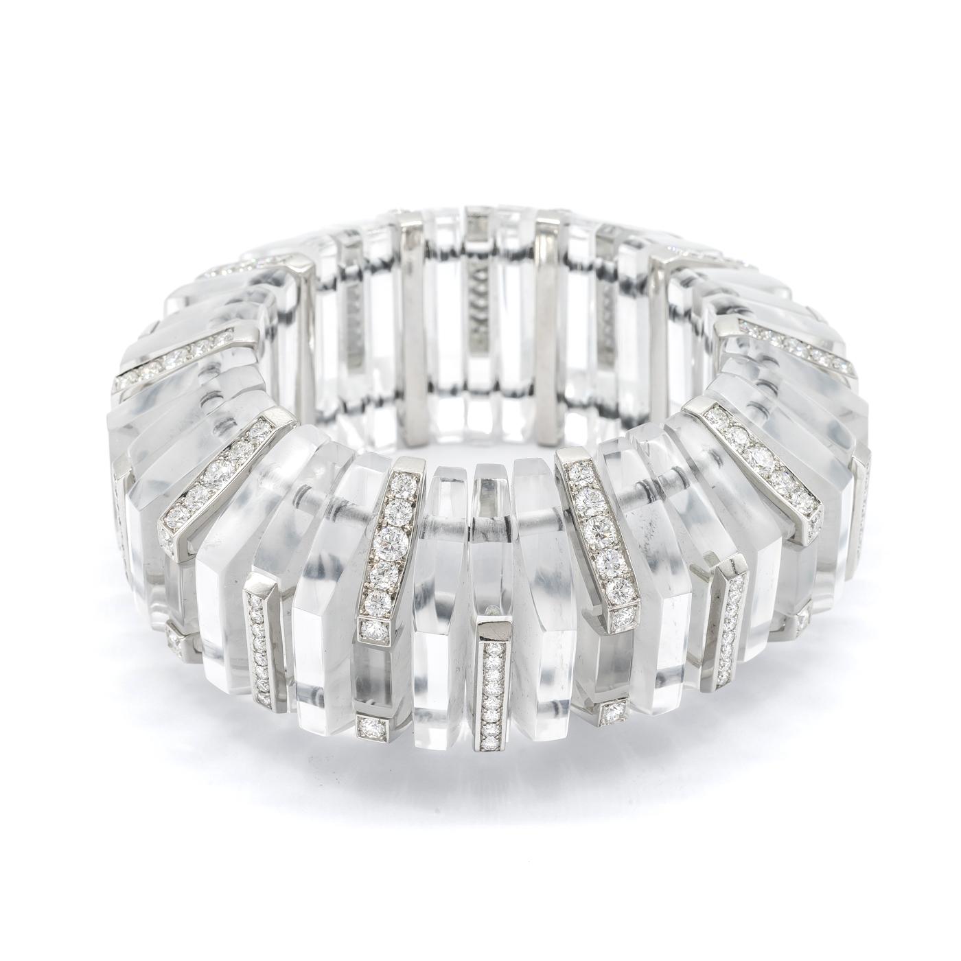 A rock crystal and diamond geometric expanding cuff bracelet, designed as a repeating pattern of half hexagon, rock crystal segments, alternating with overlaid diamond links, one with the diamonds on the front facet, the other with the diamonds on