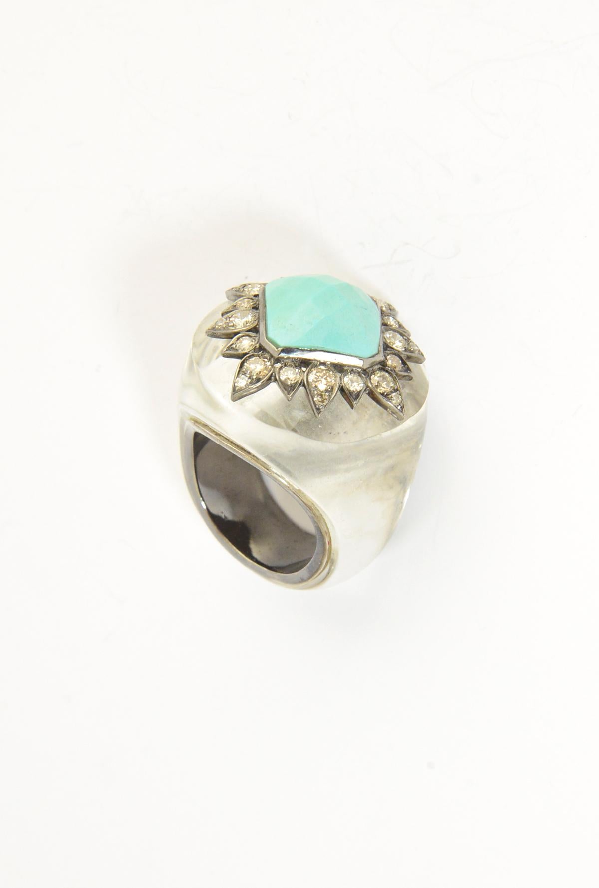 Stunning rock crystal cocktail ring with star design featuring a centrally set faceted piece of reconstituted turquoise in a diamond leaf  frame.  The interior band is sterling silver.

The ring measures 1.02
