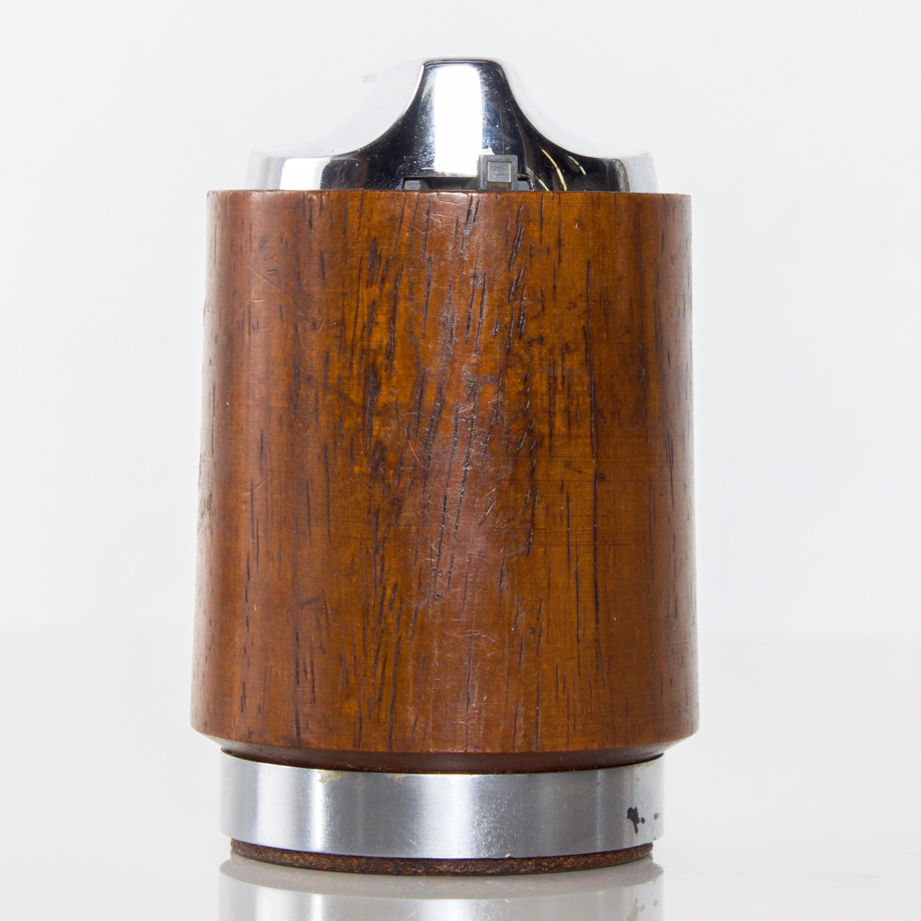 Ronson Varaflame teak table lighter with chrome. Made in England Mid-Century Modern, 1960s.
Stamped MADE IN ENGLAND, REG.TRADE.
Measures: 3.5 x 2.25 inches diameter
Original vintage unrestored preowned condition. Wear and age visible. Needs