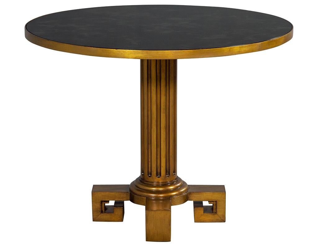 Modern round antiqued gold accent table. Stunning black detailed glass top and detailed antiqued gold column pedestal. Manufactured by Maitland Smith.

Price includes complimentary curb side delivery to the continental USA.