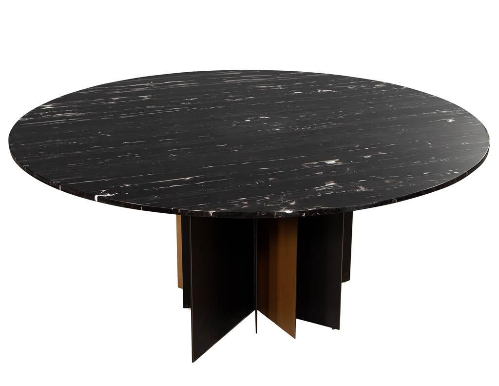 Modern round black marble top dining table. Featuring unique modern starburst metal pedestal with 3/4