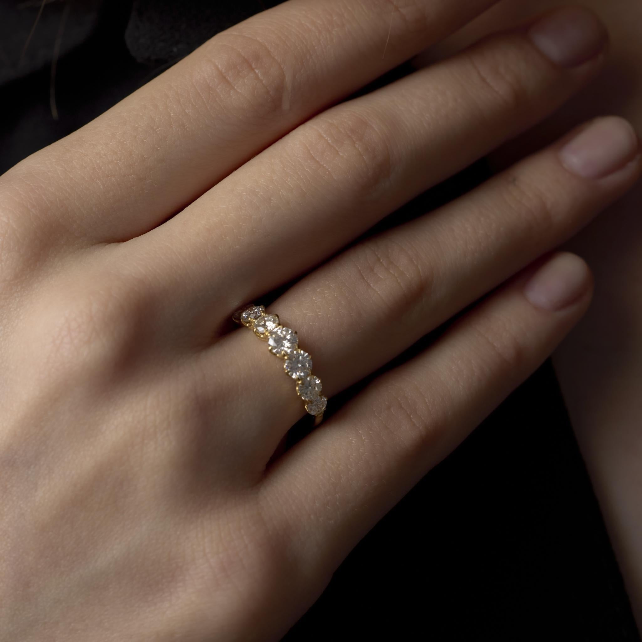 Cette élégante bague moderne en or jaune 18 carats scintille de sept diamants rayonnants, offrant un éclat raffiné et une touche intemporelle de sophistication contemporaine.