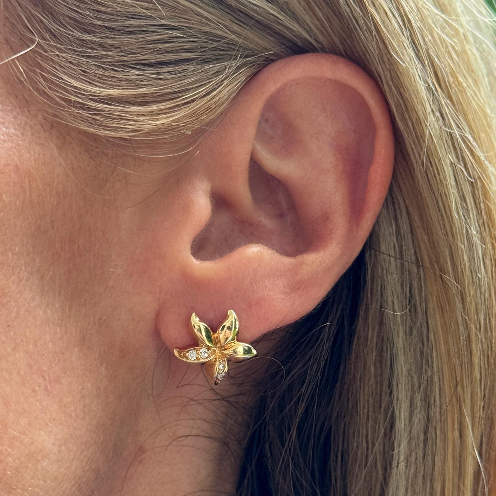 Les boucles d'oreilles fleurs en diamant présentent un délicat motif floral, réalisé en or jaune 14 carats. Les boucles d'oreilles présentent 8 diamants ronds scintillants sertis au cœur des pétales, ajoutant de l'éclat à l'élégant motif floral. Les