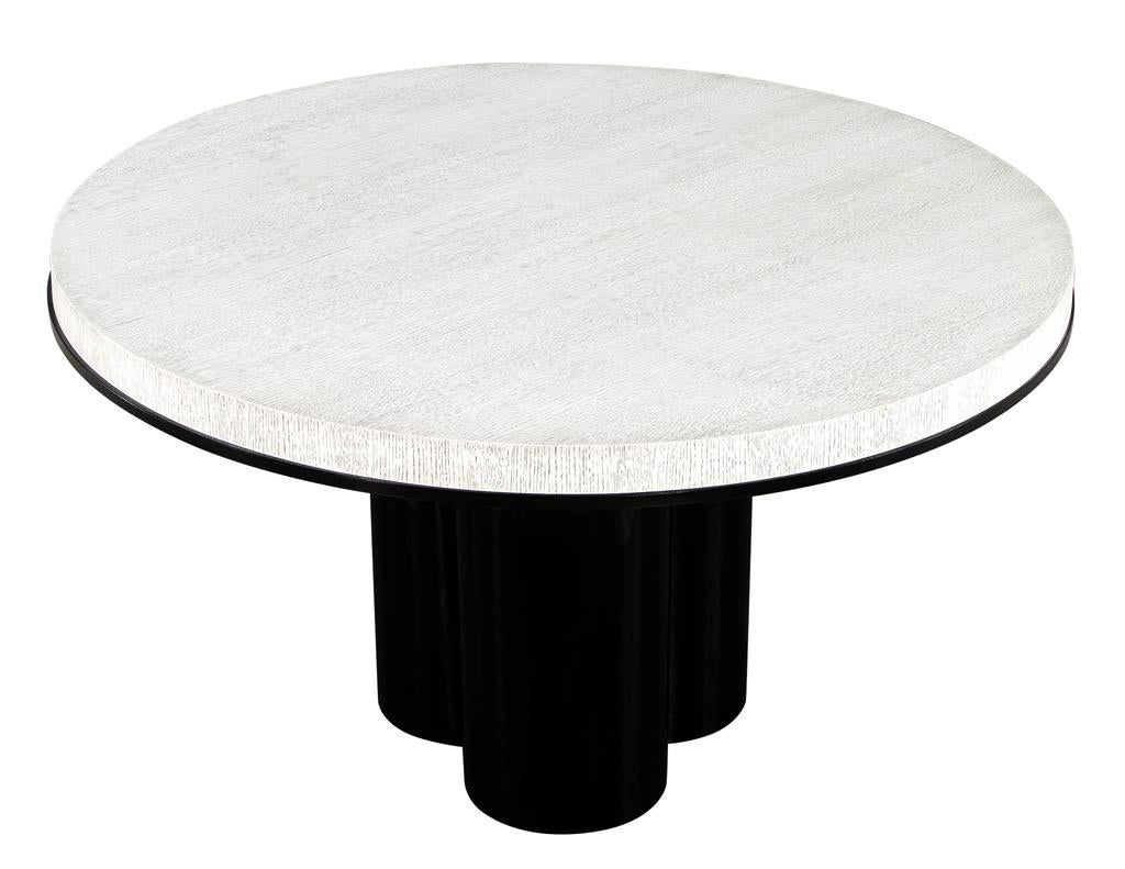 Modern round cerused oak 2 tone dining table with geometric metal base. Featuring beautifully textured cerused black and white finish with black lacquer accent ring. Resting atop a custom designed metal geometric base in a polished black finish.