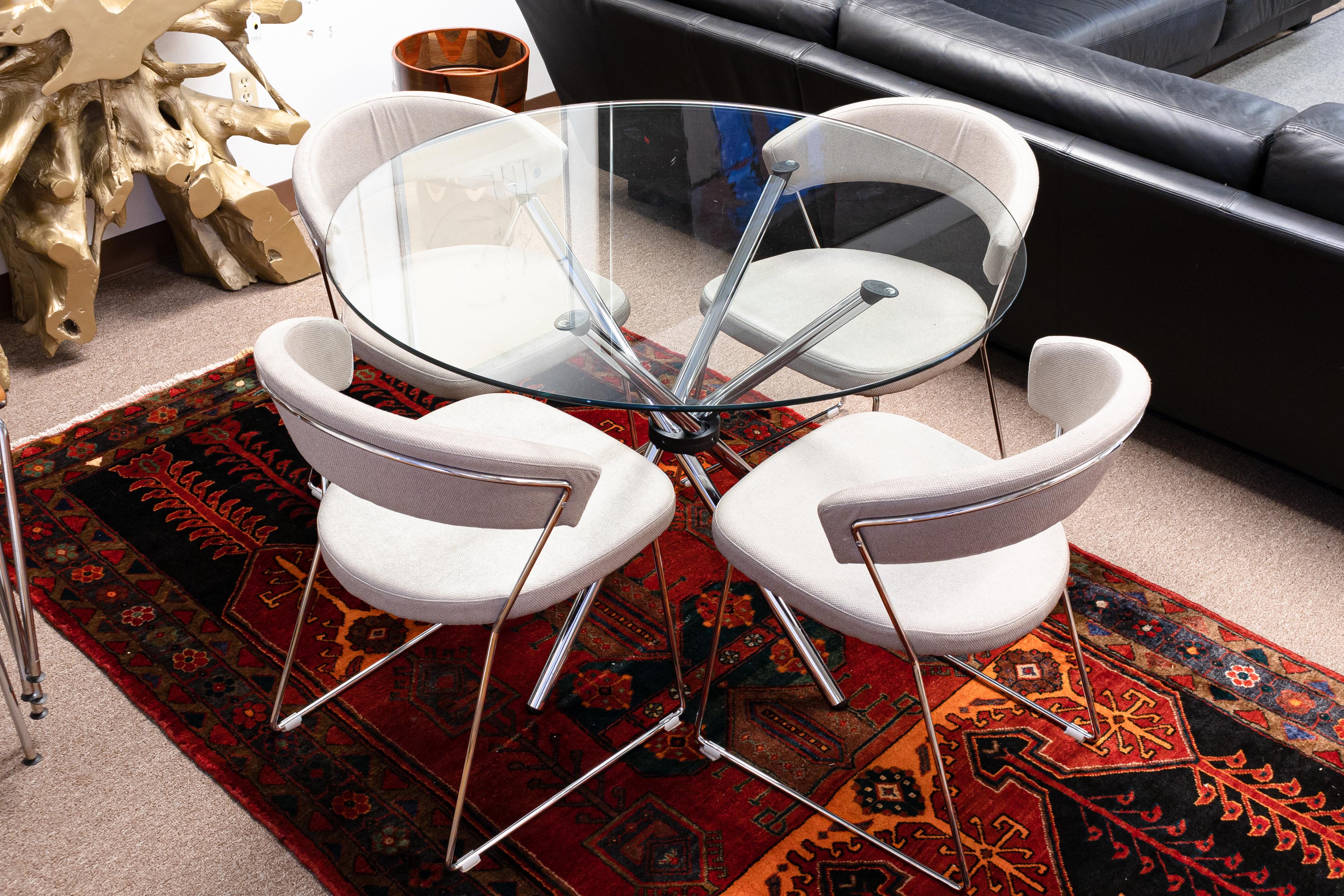 A round polished chrome and glass dinette gallery base table and a set of four Calligaris chairs. This dinette set is in very good vintage condition. It features a very unique glass dinette table with gallery style legs. The construction is very
