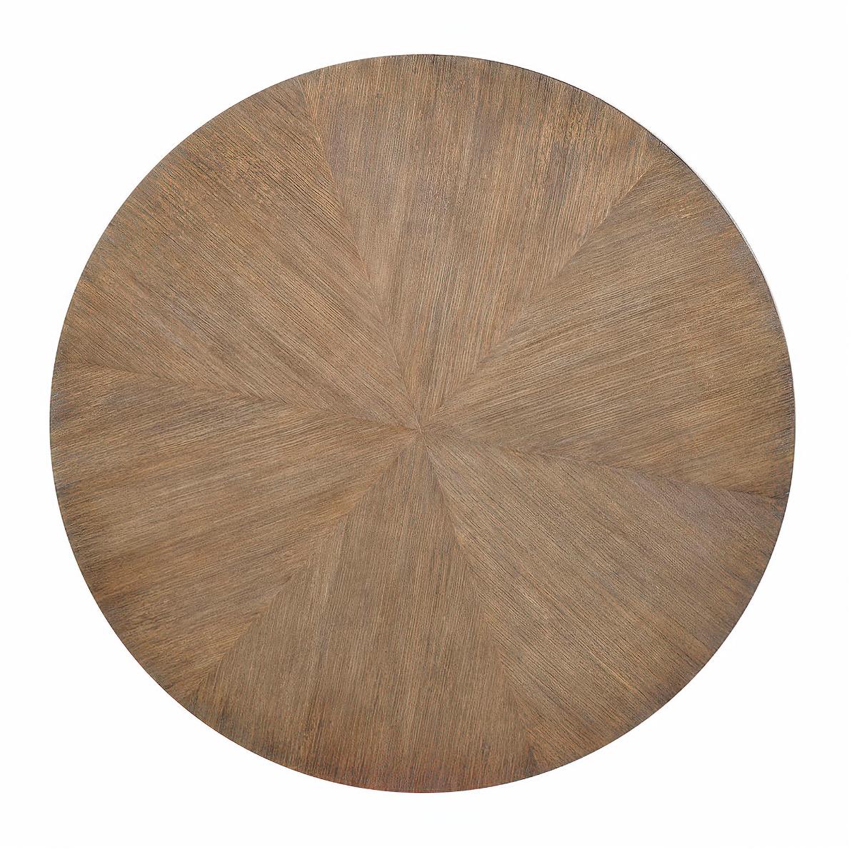 Modern round coffee table with six legs, with six-sided legs and ferrules, and a stretcher, a “natural” finish with wire brushed physical distressing and ceruse enhancing the natural highlights of the acacia veneer and an “aged bronze” finish on the