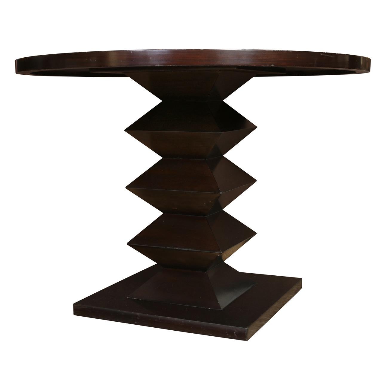 Modern round wood dining or center hall table in dark finish with zig zag pedestal base.
