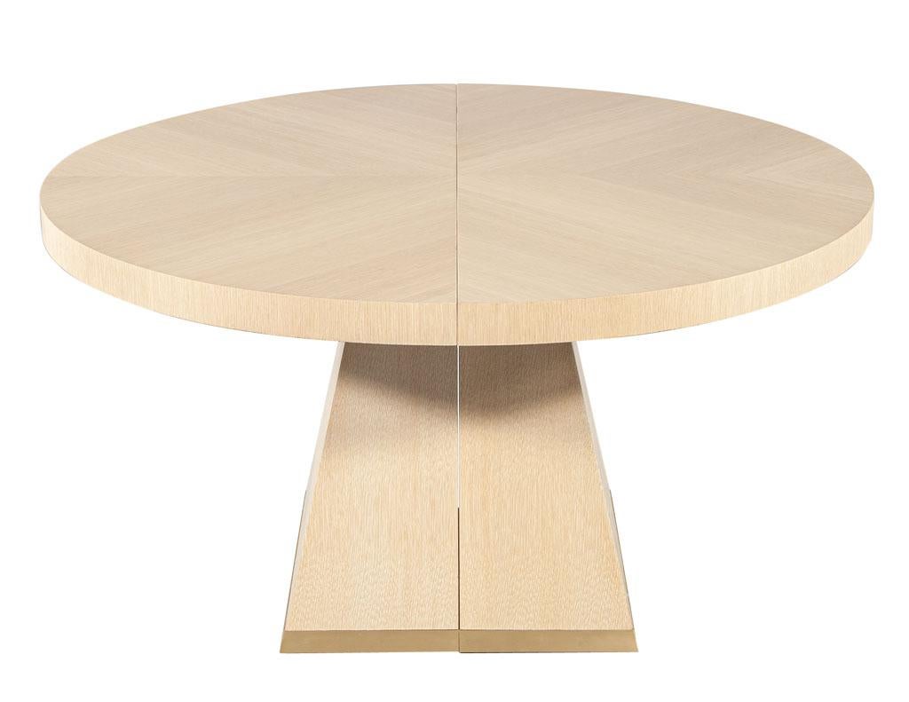 This stunning round oak dining table is a masterpiece of modern craftsmanship, meticulously handcrafted in Canada by the skilled artisans at Carrocel. Its sleek design features a 56-inch diameter round tabletop that can be seamlessly expanded to 116